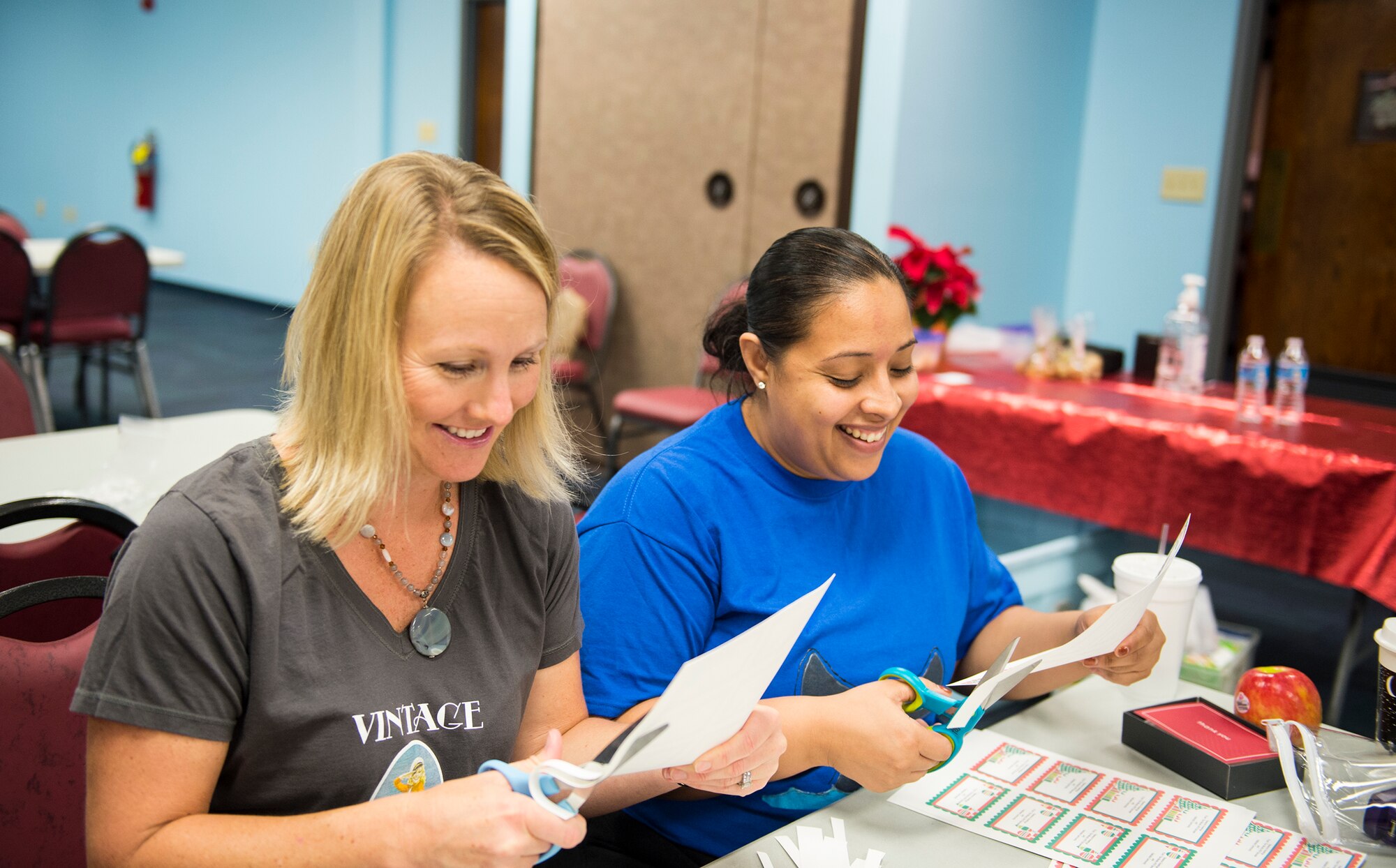 Erin Locke, left, wife of U.S. Air Force Col. Joseph Locke, 93d Air Ground Operations Wing, and Lynn Forrester, wife of Master Sgt. Anthony Forrester, 23d Civil Engineer Squadron, share a laugh while preparing gift bags during the Annual Airmen’s Cookie Drive, Dec. 2, 2015, at Moody Air Force Base, Ga. Moody’s Spouses' Club and volunteers sorted and bagged the cookies to be picked up by the first sergeants and delivered to Airmen living in the dorm. (U.S. Air Force photo by Senior Airman Ceaira Tinsley/Released)