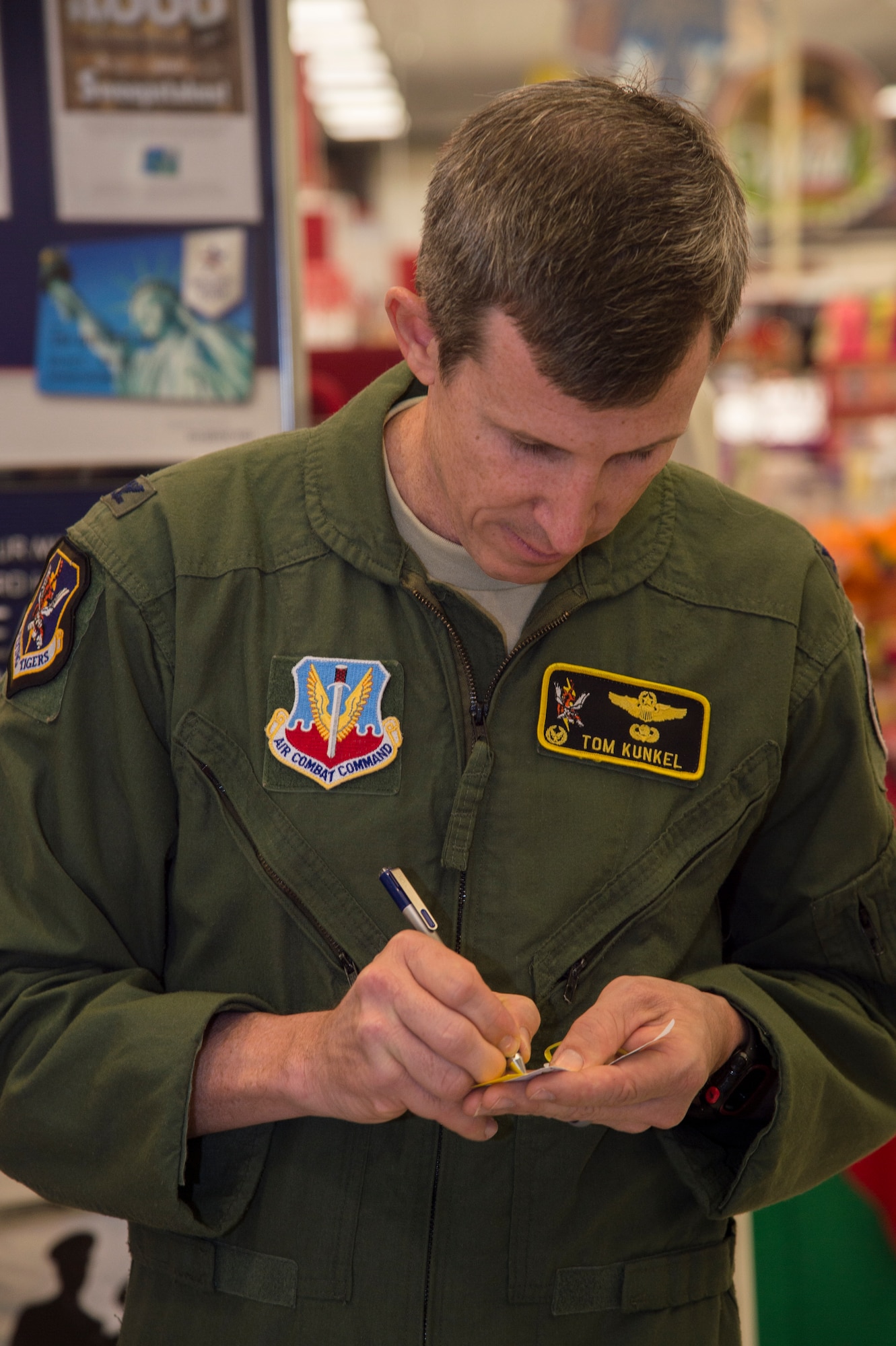 U.S. Air Force Col. Thomas Kunkel, 23d Wing commander, writes contact information on the back of an Angel Tree ornament so he can donate gifts during the Angel Tree unveiling, Nov. 30, 2015, at Moody Air Force Base, Ga. Kunkel and his wife were the first to choose names from the tree and donate gifts to children this year. (U.S. Air Force photo by Staff Sgt. Eric Summers Jr./Released)