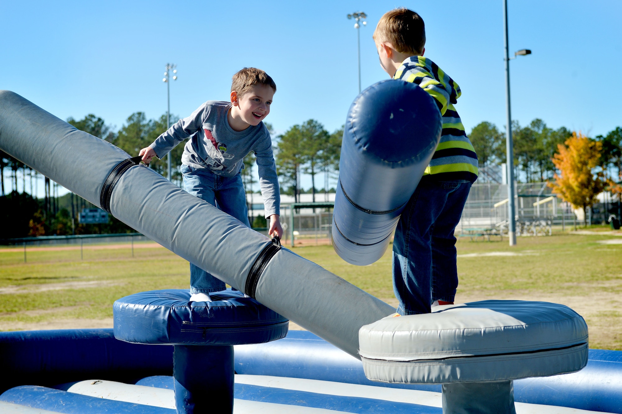 Two Team Shaw family members participate in the pugil stick challenge during a Fall Family Picnic event at Shaw Air Force Base, S.C., Nov. 21, 2015. The games provided by 20th Fighter Wing volunteers encouraged participants to work with one another, building relationships within the Team Shaw community. (U.S. Air Force photo by Senior Airman Diana M. Cossaboom)
