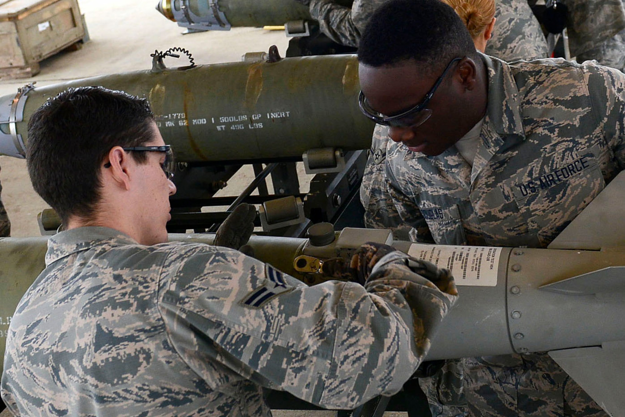 Team Shaw Airmen bolt the fin on an inert guided bomb unit during an Ammo assembly demonstration at Shaw Air Force Base, S.C., Dec. 1, 2015. Non-muntions Airmen were given the opportunity to build bombs and learn about the various duties that 20th Equipment Maintenance Squadron Airmen execute on a daily basis.  (U.S. Air Force photo by Airman 1st Class Christopher Maldonado)
