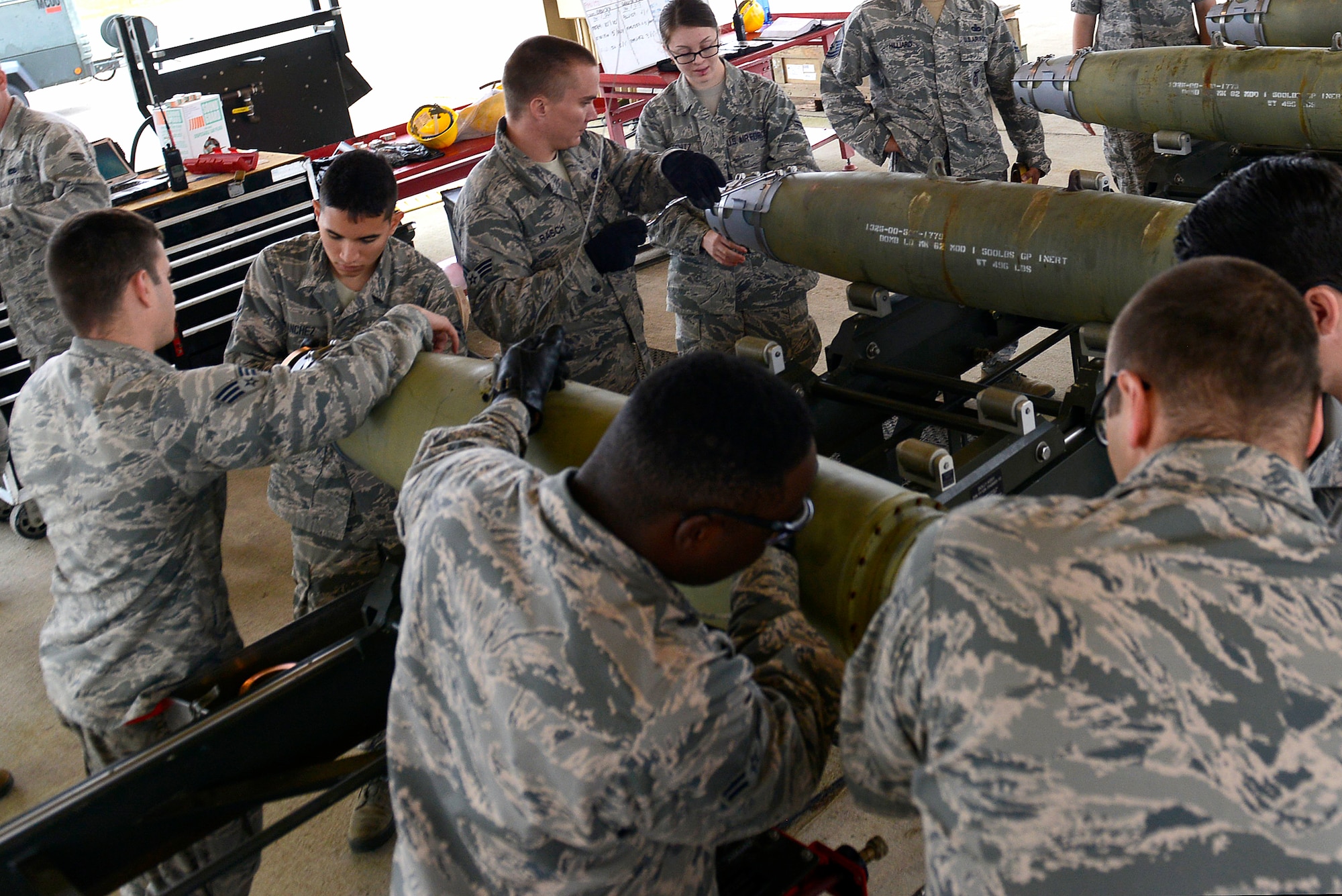 Team Shaw Airmen begin the assembly of an inert guided bomb during an Ammo assembly demonstration at Shaw Air Force Base, S.C., Dec. 1, 2015. Airmen assigned to the 20th Equipment Maintenance unit gave non-munitions Airmen various instructions and tips throughout the assembly process, as well as safety briefings on what to do around the different pieces of munitions. (U.S. Air Force photo by Airman 1st Class Christopher Maldonado)