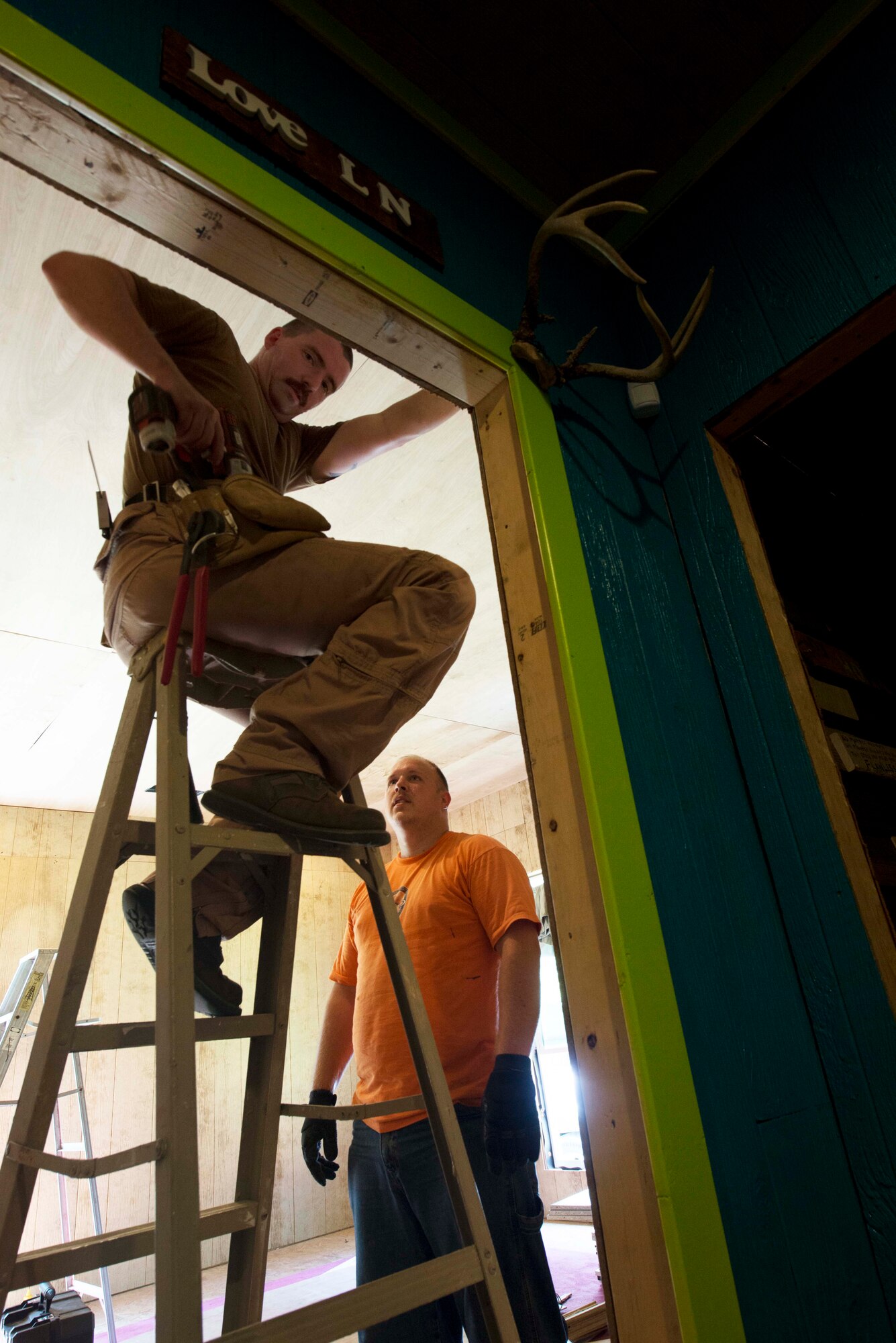 Staff Sgt. Jody Perkins, Air Force Center for Electronic Distribution and Systems developer, right, and Tech Sgt. Jonathan Kirby, AFCED noncommissioned officer in charge, nail wood paneling onto the walls of a bedroom in the battered and homeless women and children shelter Sept. 4, 2015 in Shorter, Ala. Hand’s Off Women is a nonprofit organization that is aimed at promoting and protecting women’s and children’s human and civil rights, while eliminating violence against women. (U.S. Air Force photo by Airman 1st Class Alexa Culbert) 