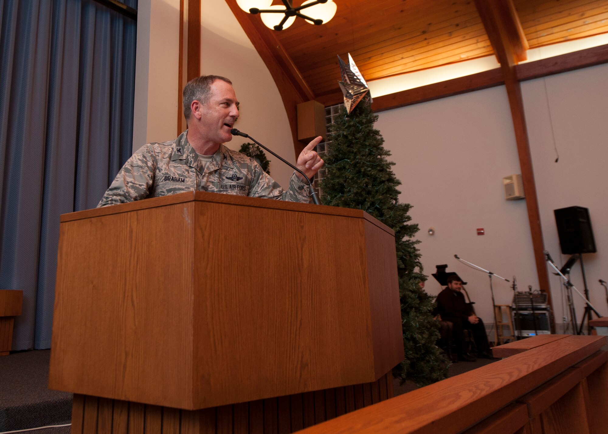 Col. Robert Graham, 436th Airlift Wing acting vice commander, speaks to a crowd of Team Dover Airmen and their families during the 2015 Dover Air Force Base Holiday Tree Lighting ceremony Dec. 1, 2015, at Chapel 2 on Dover AFB, Del. Graham spoke on the importance of families during the holiday season and to think about the Team Dover Airmen who are currently deployed. (U.S. Air Force photo/Senior Airman Zachary Cacicia)