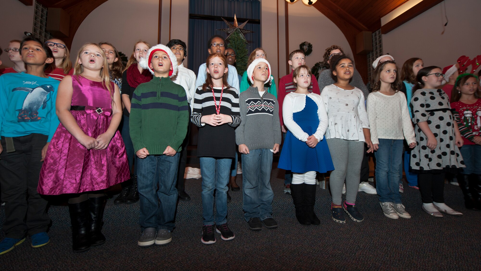 Children from the Welsh Elementary School chorus sing carols during the 2015 Dover Air Force Base Holiday Tree Lighting ceremony Dec. 1, 2015, at Chapel 2 on Dover AFB, Del. The tree lighting ceremony is an annual event that is hosted by the chapel staff. (U.S. Air Force photo/Senior Airman Zachary Cacicia)