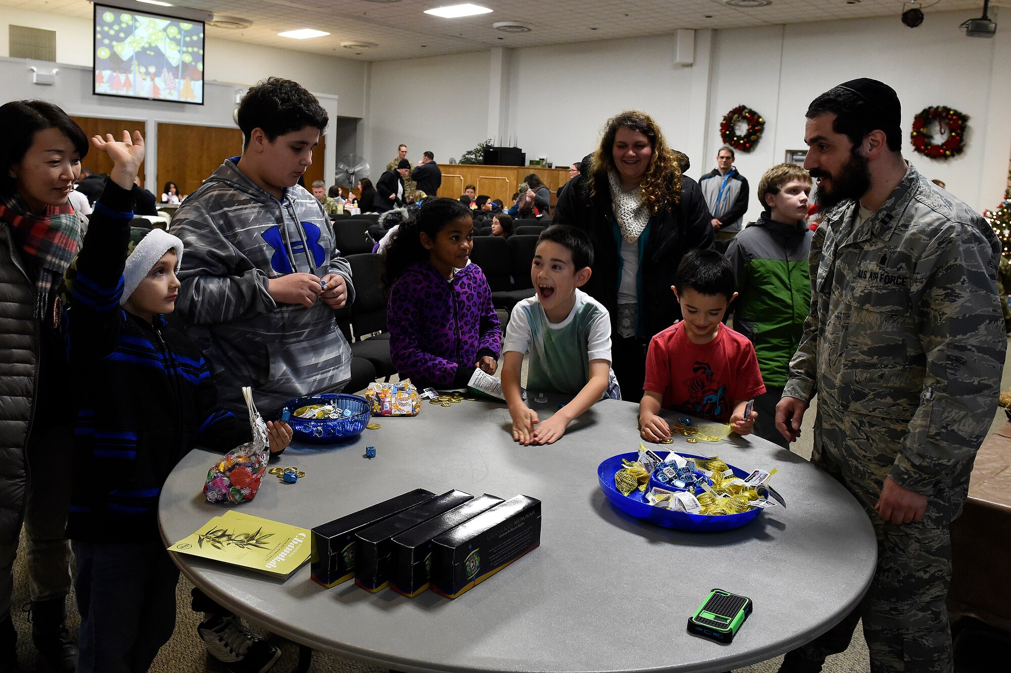 Children learn how to play the game of dreidel during the McChord Field Annual Holiday Lighting Ceremony Dec. 2, 2015 at Joint Base Lewis-McChord, Wash. Dreidel means “to turn around” in Yiddish and is played during the Jewish holiday, Hanukkah. (U.S. Air Force photo by Tech. Sgt. Tim Chacon)