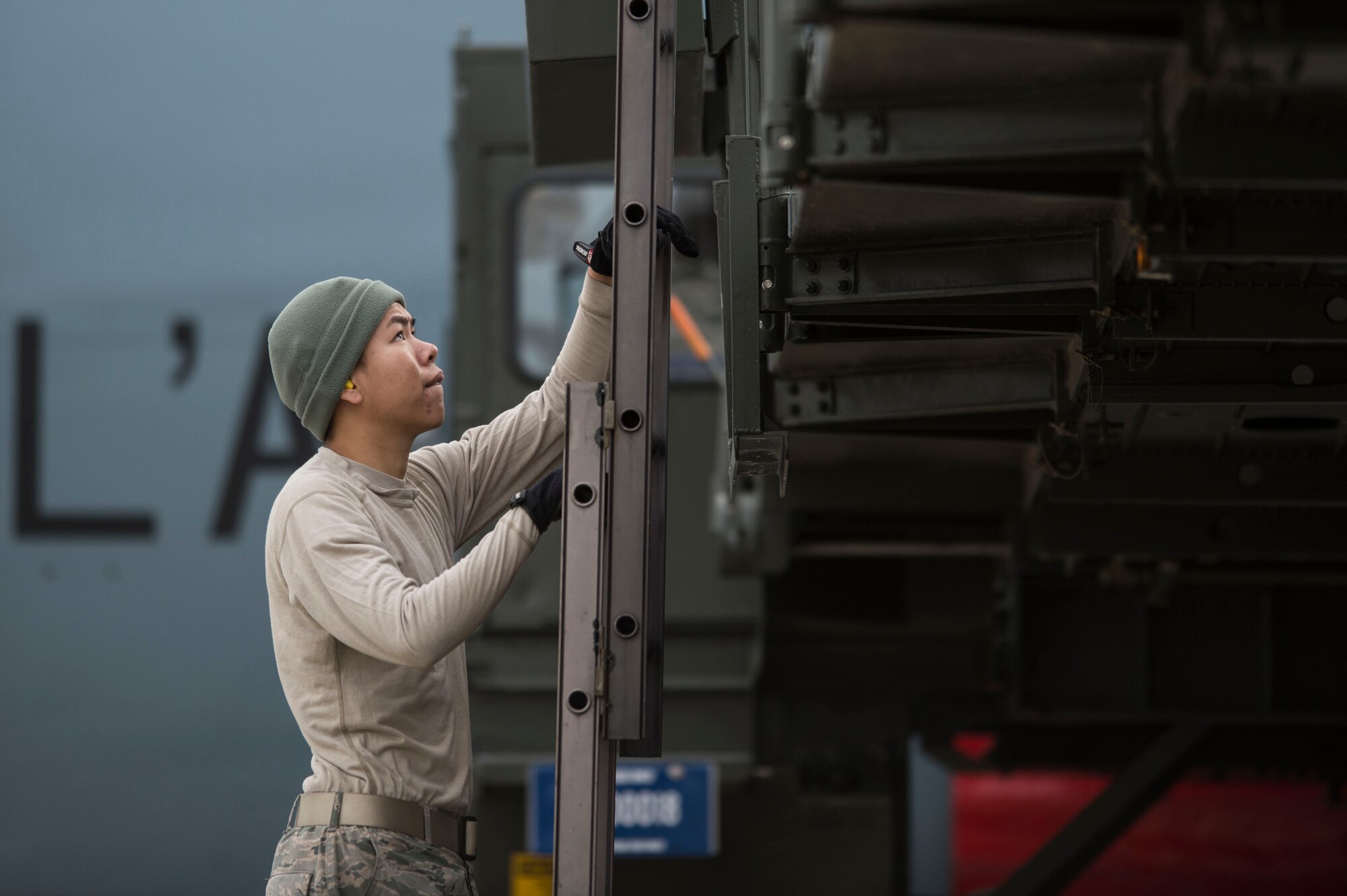 A U.S. Airman climbs a cargo loader at Langley Air Force Base, Va., Dec. 1, 2015. Airmen assisted French Air Force personnel as they arrived for the start of the inaugural Trilateral Exercise between the U.S. Air Force and the British Royal Air Force. (U.S. Air Force photo by Senior Airman Kayla Newman)