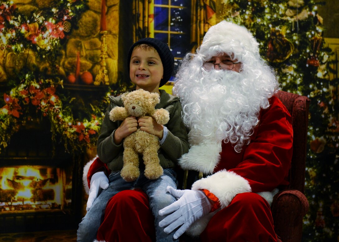 Chase, son of U.S. Air Force Master Sgt. Amanda Layton, sits with Santa Claus after the annual holiday tree lighting event, Dec. 1, 2015, at Aviano Air Base, Italy. Santa rode in on a fire engine provided and driven by 31st Civil Engineer Squadron fire department personnel. (U.S. Air Force photo by Senior Airman Austin Harvill/Released)