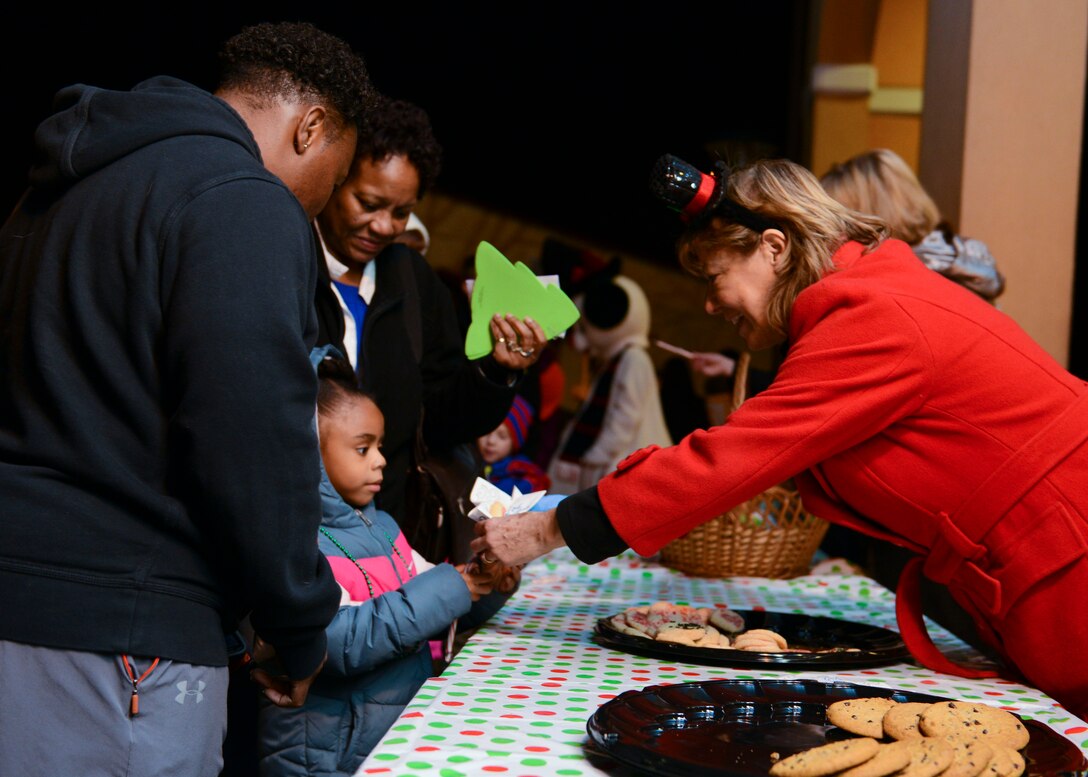 A holiday helper hands a young Wyvern a free cookie during the annual holiday tree lighting event, Dec. 1, 2015, at Aviano Air Base, Italy. In addition to cookies, the 31st Force Support Squadron offered free candy and hot chocolate to attendees. (U.S. Air Force photo by Senior Airman Austin Harvill/Released)