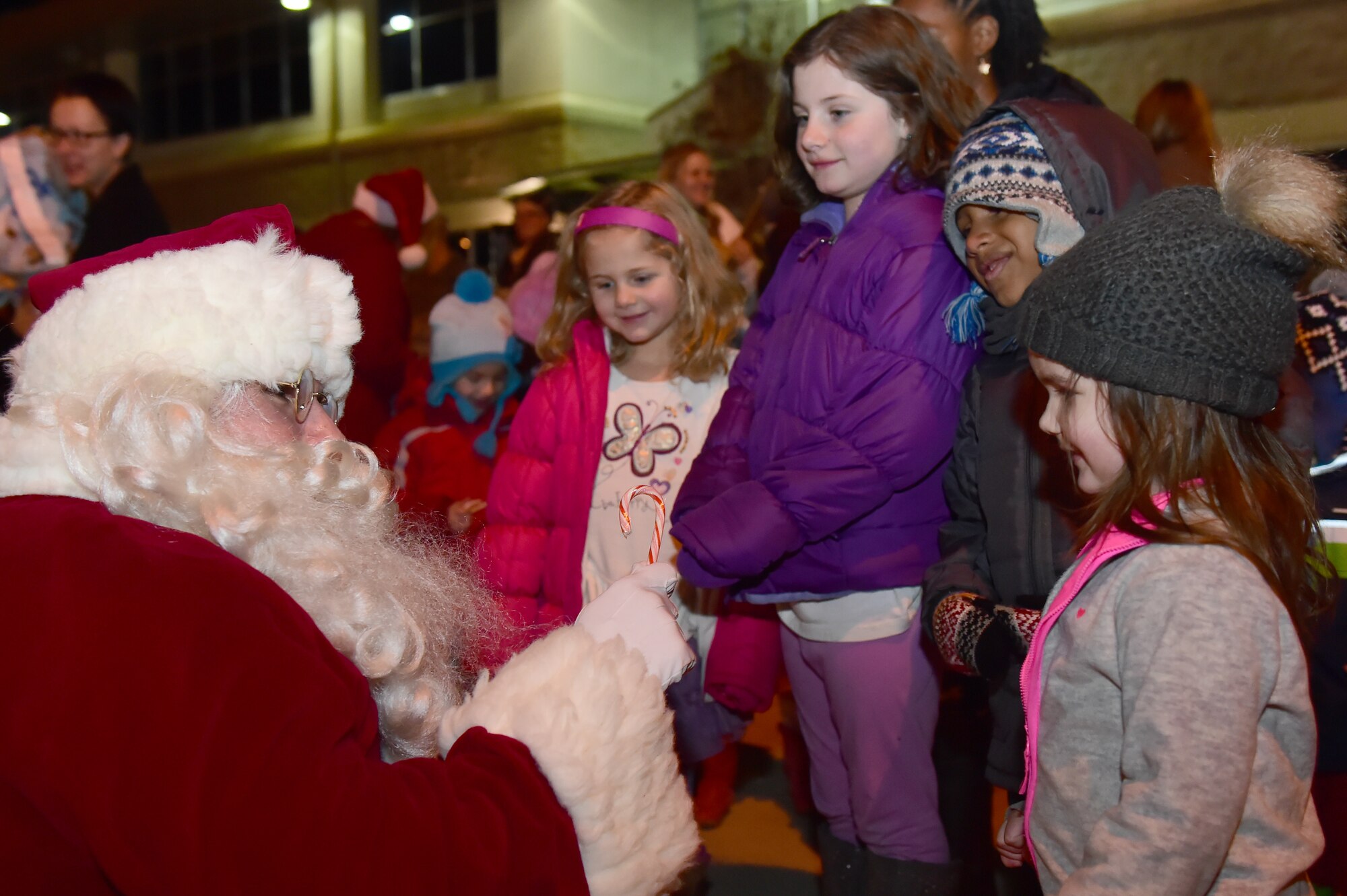 Santa Claus hands out candy canes to children Dec. 2, 2015, on Buckley Air Force Base, Colo. Members of Team Buckley gathered for the annual tree-lighting ceremony which included carolers, refreshments and Santa Claus to celebrate the holiday season. (U.S. Air Force photo by Airman 1st Class Luke W. Nowakowski/Released)