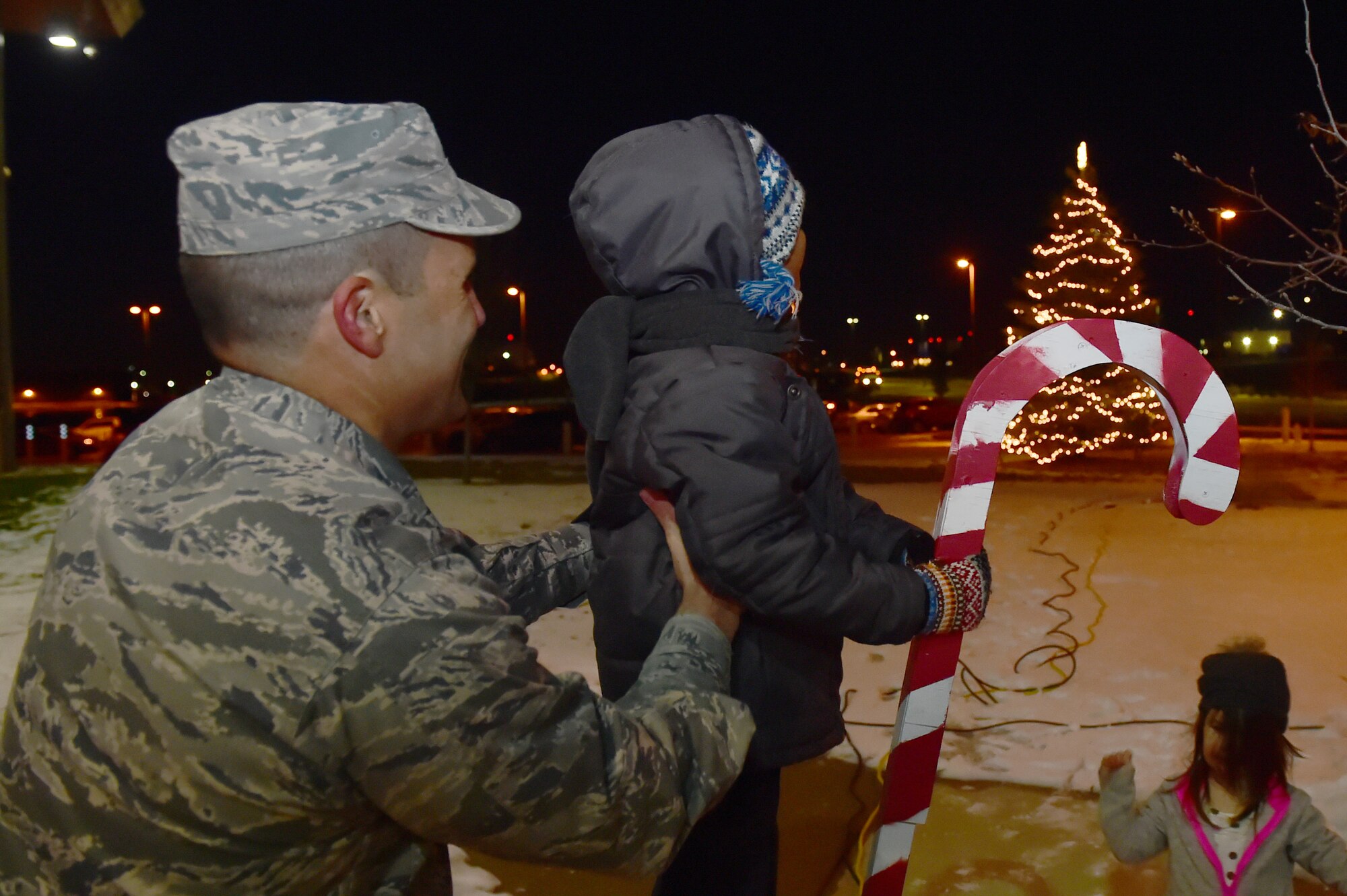 Col. John Wagner, 460th Space Wing commander, helps a child light the tree in front of the 460th SW Headquarters Building Dec. 2, 2015, on Buckley Air Force Base, Colo. Members of Team Buckley gathered to celebrate and enjoy refreshments in honor of the holiday season. (U.S. Air Force photo by Airman 1st Class Luke W. Nowakowski/Released)