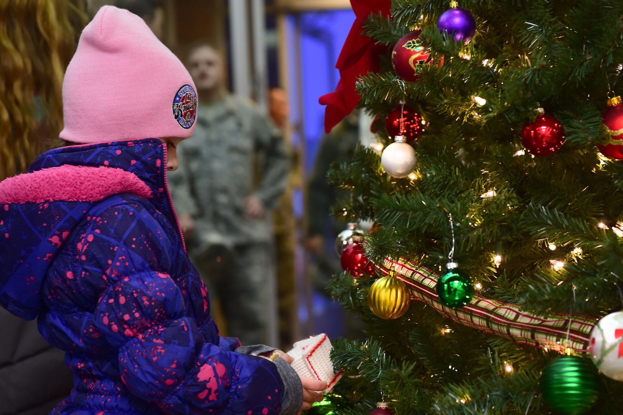 A child from the Buckley AFB community admires an ornament Dec. 2, 2015, on Buckley Air Force Base, Colo. Members of Team Buckley gathered for the annual tree-lighting ceremony which included carolers, refreshments and Santa Claus  to celebrate the holiday season. (U.S. Air Force photo by Airman 1st Class Luke W. Nowakowski/Released)