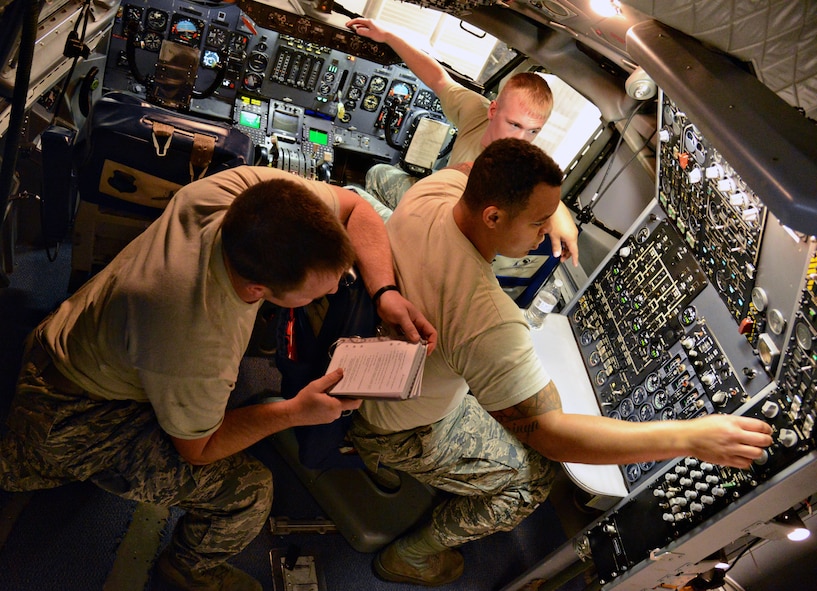 Students, from left, Senior Airman Brent Tester, Senior Airman Matthew Harwood and Staff Sgt. Chandler Donaldson, all with the 552nd Aircraft Maintenance Squadron, work together in a simulated E-3 cockpit to solve tasks using technical orders. The Airmen are students with Detachment 9, an Air Education and Training Command unit geographically separated from the 373rd Training Squadron at Sheppard Air Force Base, Texas. (Air Force photo by Kelly White/Released)