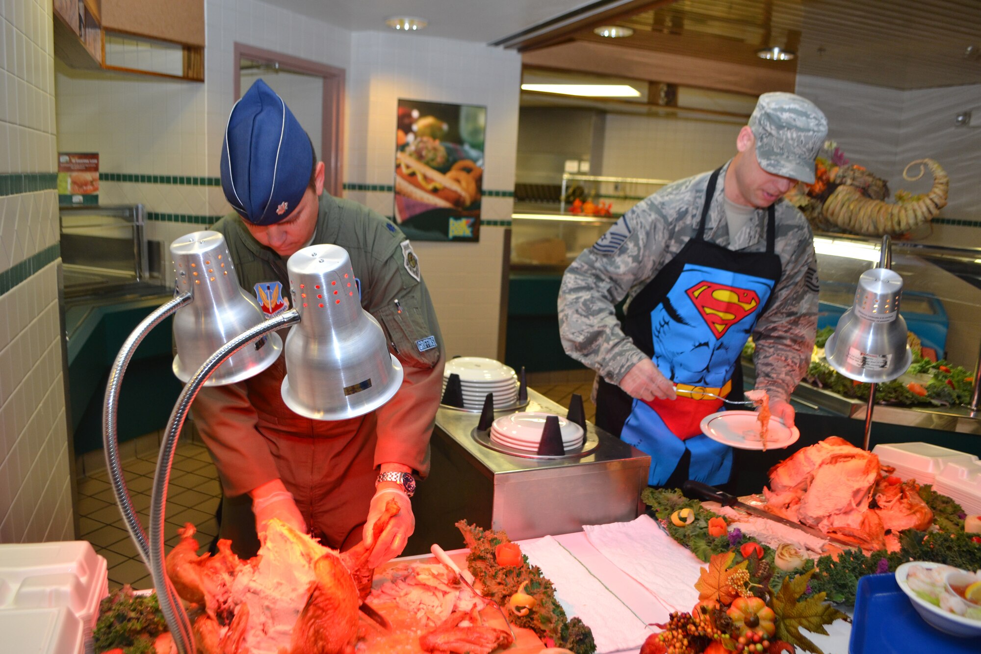 Lt. Col. Ryan Jones, 552nd Training Squadron commander, left, and Master Sgt. Steven Colombo, 552nd TRS first sergeant, serve up turkey to patrons at the Vanwey Dining Facility on Thanksgiving. (Air Force photo by Ron Mullan/Released)