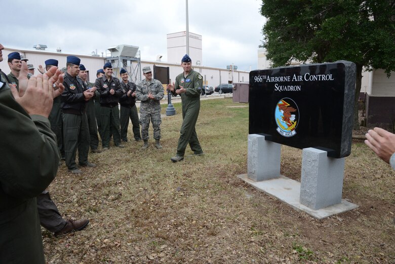 Lt. Col. Christian Egan, 966th Airborne Air Control Squadron commander, center, and members of his squadron celebrate at the unveiling at their new granite sign in front of their building on Nov. 25.The squadron moved from the south side of the base to Bldg. 201W six months ago and the long-awaited sign in front of their building solidifies their home near the rest of the AWACS facilities. “This sign is a symbol of pride and belonging for all the Eagles,” Tech. Sgt. Stanley Chatham said, noting the floods, fires and other issues the squadron has dealt with since moving into their new location. “Today, they leave these problems in the past and truly have a home worthy of their dedication to the mission.” (Air Force photo by Kelly White/Releaesed)