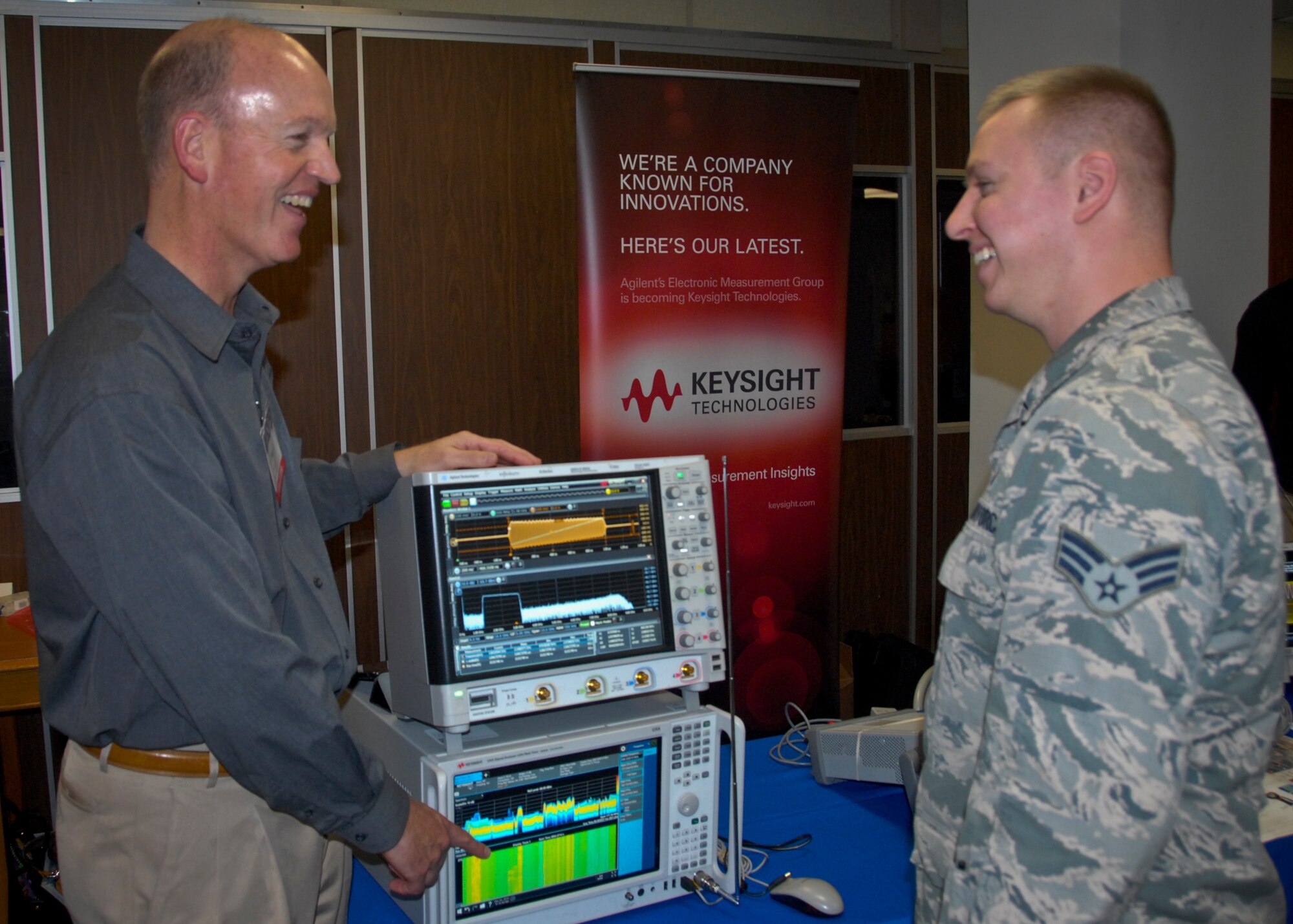 Philip Stallcup, from Keysight Technologies, a test and measurement equipment and software manufacturer, briefs Senior Airman Joseph Allen, of the 28th Test and Evaluation Squadron, on an oscilloscope and spectrum analyzer used for radio frequency and electronic warfare testing, at the Technology Expo, at Eglin Air Force Base, Fla. Dec. 3.  More than 30 exhibitors from across the country offered information and displays about the latest defense technologies; storage solutions; and logistical and engineering services, among other technologies.  (U.S. Air Force photo/Kevin Gaddie)   