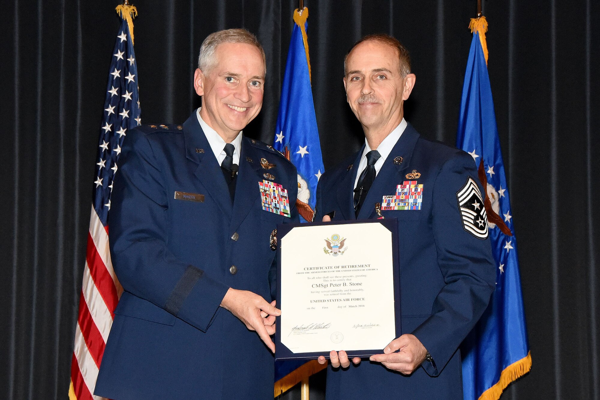 Maj. Gen. Rick Martin, U.S. Air Force Expeditionary Center commander, presents Chief Master Sgt. Pete Stone with his retirement certificate during a ceremony Nov. 30., at Joint Base McGuire-Dix-Lakehurst, N.J. Stone, a native of New Hampshire, retires after serving 30 years on active duty.(U.S. Air Force photo/Danielle Brooks)