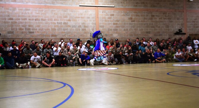 Harlem Globetrotters mascot Globey high-fives service members as he enters the gym at an undisclosed location in Southwest Asia, Nov. 30, 2015. The Harlem Globetrotters are an exhibition basketball team that performs for audiences all over the world. (U.S. Air Force photo by Staff Sgt. Jerilyn Quintanilla)