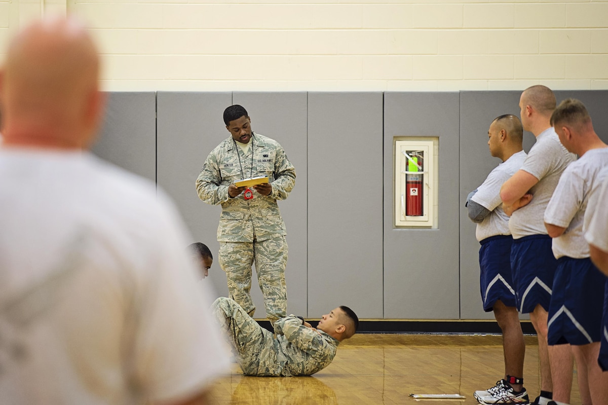 Staff Sgt. Ala Hunter, 512th Memorial Affairs Squadron, reads the instructions on performing a proper sit-up before assessing 512th Airlift Wing reservists on Dover Air Force Base, Del., Nov. 11, 2015. - The 512th Airlift Wing assumed control of reservists’ physical fitness assessment here, during the Unit Training Assemblies, beginning November 7. (U.S. Air Force photo/Capt. Bernie Kale)