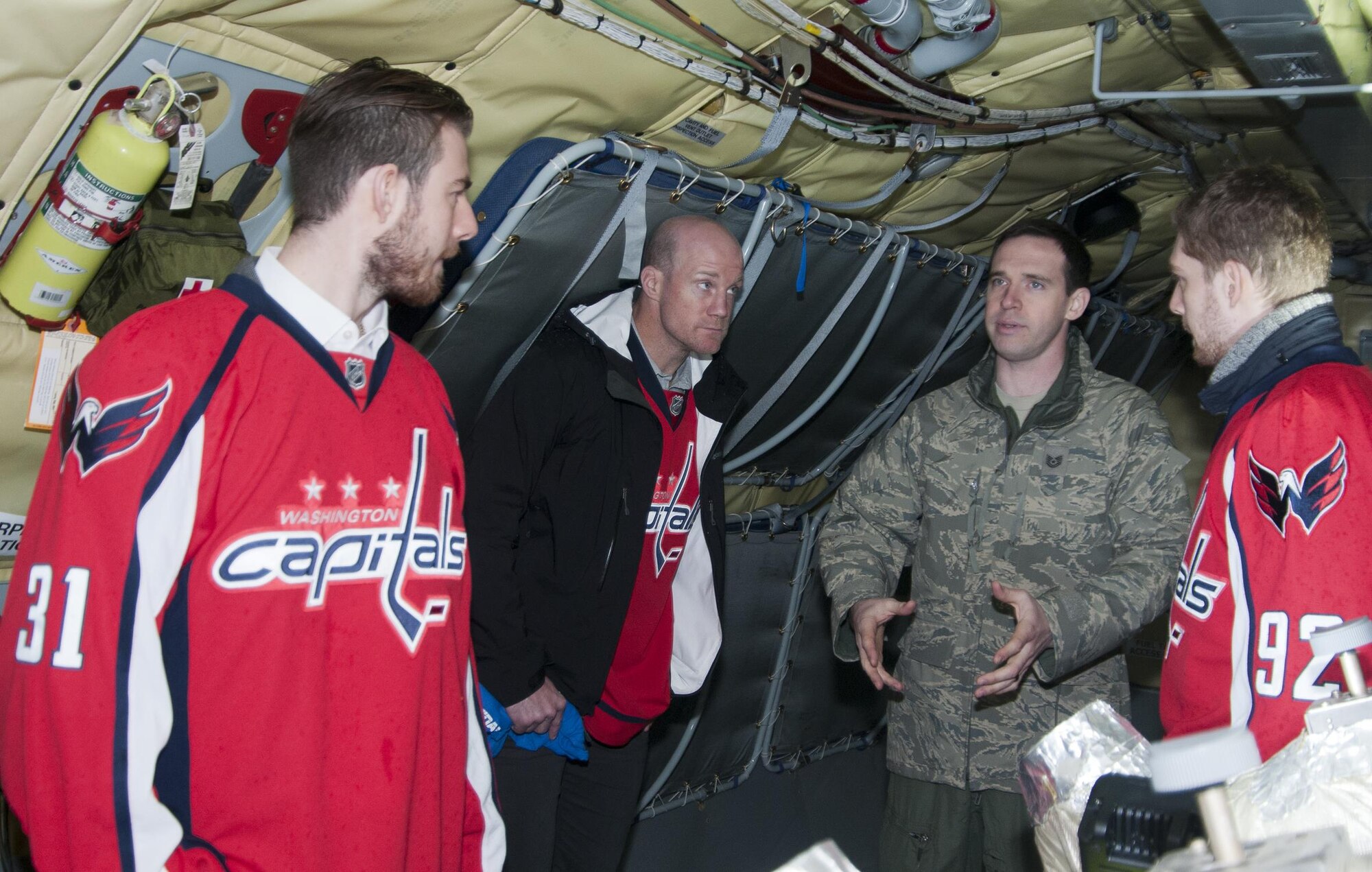 Technical Sgt. Matt Oberlin, 756th Air Refueling Squadron boom operator (right), explains the role and operations of a boom operator to a group of Washington Capitals players on board a 459th Air Refueling Wing KC-135R Stratotanker on Joint Base Andrews, Md., flight line Dec. 1, 2015. . The Capitals visited JBA to learn about the Air Force mission here. They observed special performances by the U.S. Air Force band Max Impact, Honor Guard, 11th Wing Explosive Ordnance Disposal, as well as static displays from the 1st Helicopter Squadron and 459 ARW, 113th Wing, Air National Guard. (U.S. Air Force photo by Staff. Sgt. Kat Justen)
