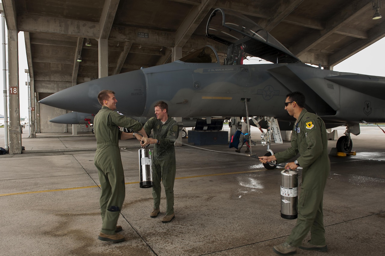 U.S. Air Force Lt. Col. Alexander Haddad, 44th Fighter Squadron pilot, gets sprayed with water by 1st Lts. Maxwell Anthony (left) and Michael Tope, 44th FS pilots, after Haddad reached 2,000 F-15 flying hours at Kadena Air Base, Japan, Nov. 19, 2015. It is a tradition for pilots to get sprayed down with water after reaching a significant milestone. U.S. Air Force photo by Airman 1st Class Corey M. Pettis