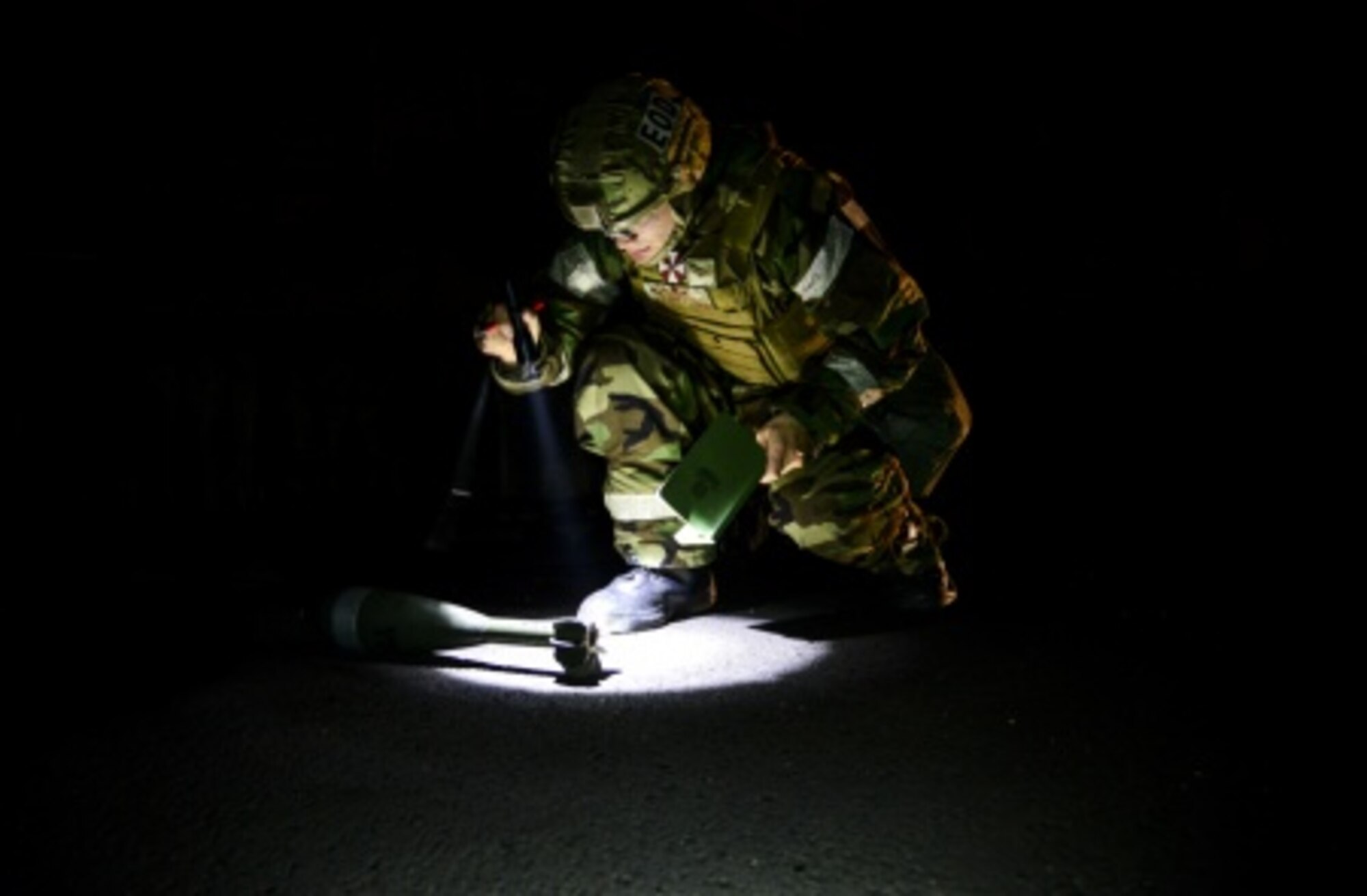 Airman 1st Class James Boyce, a 51st Civil Engineer Squadron explosive ordnance disposal technician, inspects a simulated unexploded mortar round during a training scenario at Osan Air Base, South Korea, Nov. 6, 2015. EOD Airmen inspect UXOs to accurately determine the best way to either correctly disarm or detonate them in a controlled environment. (U.S. Air Force photo/Tech. Sgt. Travis Edwards)