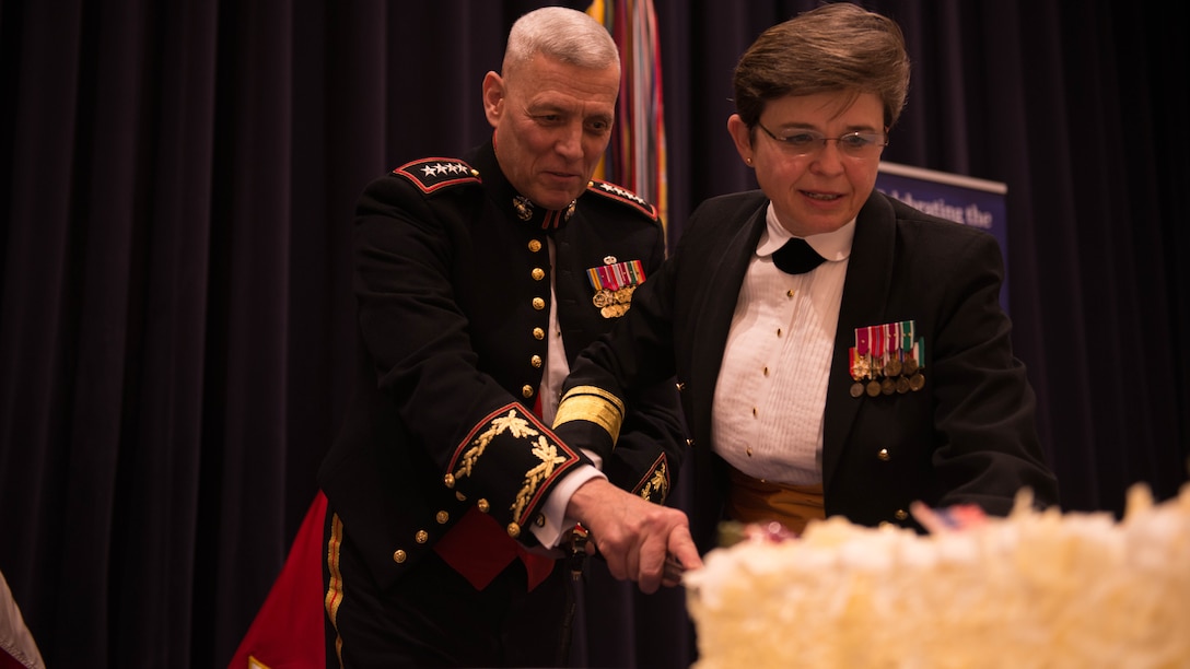 The 33rd Assistant Commandant of the Marine Corps Gen. John M. Paxton Jr. assists Rear Adm. Margaret G. Kibben, the 26th Chief of Chaplains, cut the cake during the celebration of the 240th Anniversary of the Navy Chaplain Corps at Crawford Hall in Marine Barracks Washington, Dec. 3, 2015. 