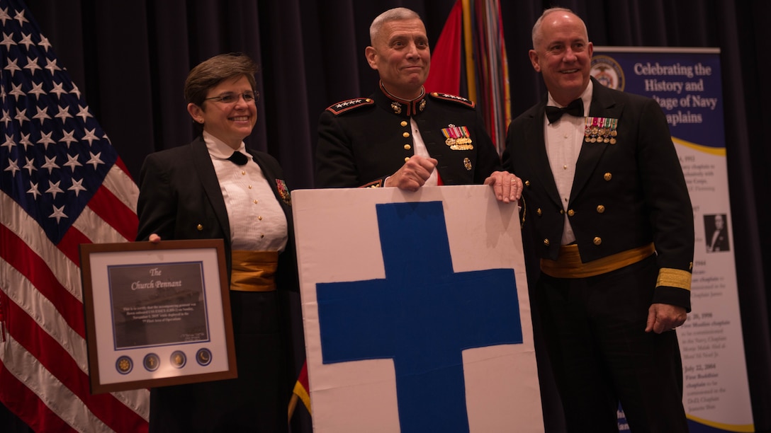 The 26th Chief of Chaplains Rear Adm. Margaret G. Kibben presents the 33rd Assistant Commandant of the Marine Corps Gen. John M. Paxton Jr., center, the Church Pennant flown on the USS ESSEX as part of the 240th Anniversary of the Navy Chaplain Corps at Crawford Hall in Marine Barracks Washington, Dec. 3, 2015. 
