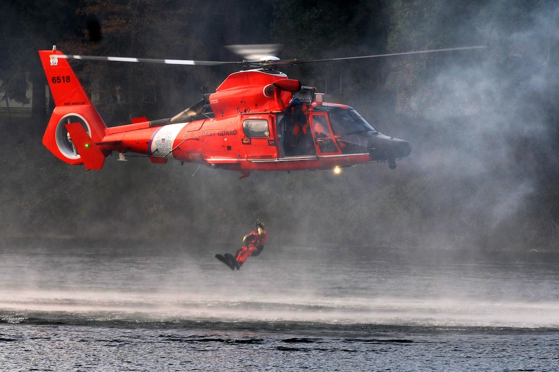 A U.S. Coast Guardsman jumps into the water during extraction training as part of a disaster management exchange event at Joint Base Lewis-McChord, Wash., Nov. 20, 2015. U. S. Army photo by Sgt. 1st Class Andrew Porch