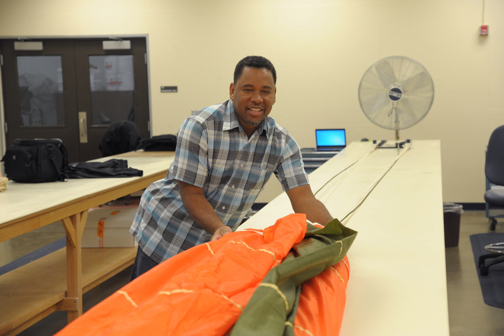 Gene Lott, 12th Operations Support Squadron flight equipment survival technician, inspects a parachute Nov. 18, 2015 at Joint Base San Antonio-Randolph. The 12th Operations Support Squadron is responsible for pilot instructor training and introduction to fighter fundamentals academic and simulator training, scheduling, air traffic control, airfield management, flight records, registrar, weather, airspace management, international training and aircrew flight equipment for all 12th Operational Group training.  (U.S. Air Force photo by Joel Martinez/Released)