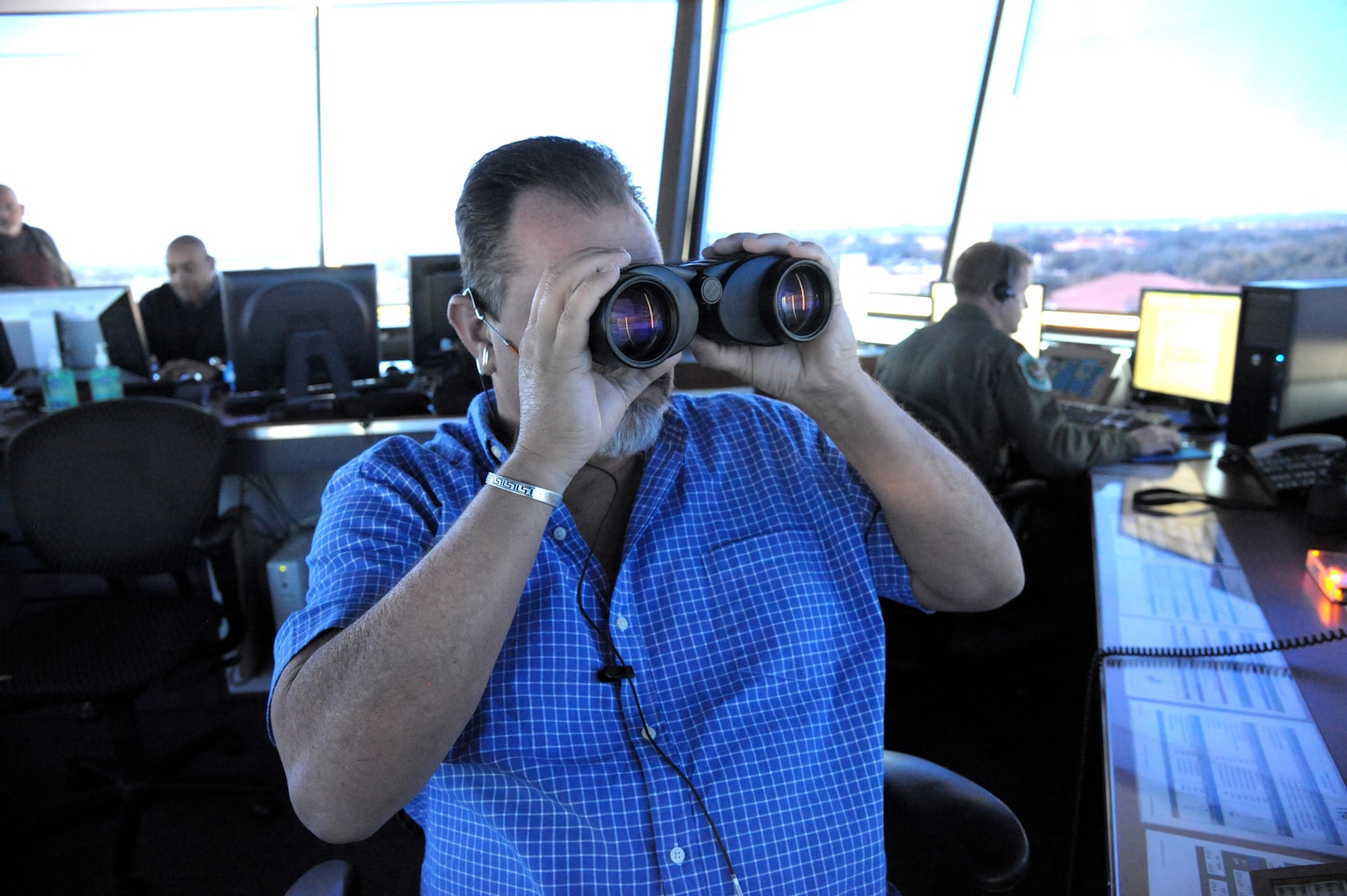 Frank Lucas, 12th Operations Support Squadron air traffic controller, looks for approaching aircraft Nov. 18, 2015 at Joint Base San Antonio-Randolph. The 12th OSS is responsible for pilot instructor training and introduction to fighter fundamentals academic and simulator training, scheduling, air traffic control, airfield management, flight records, registrar, weather, airspace management, international training and aircrew flight equipment for all 12th Operational Group training.  (U.S. Air Force photo by Joel Martinez/Released)