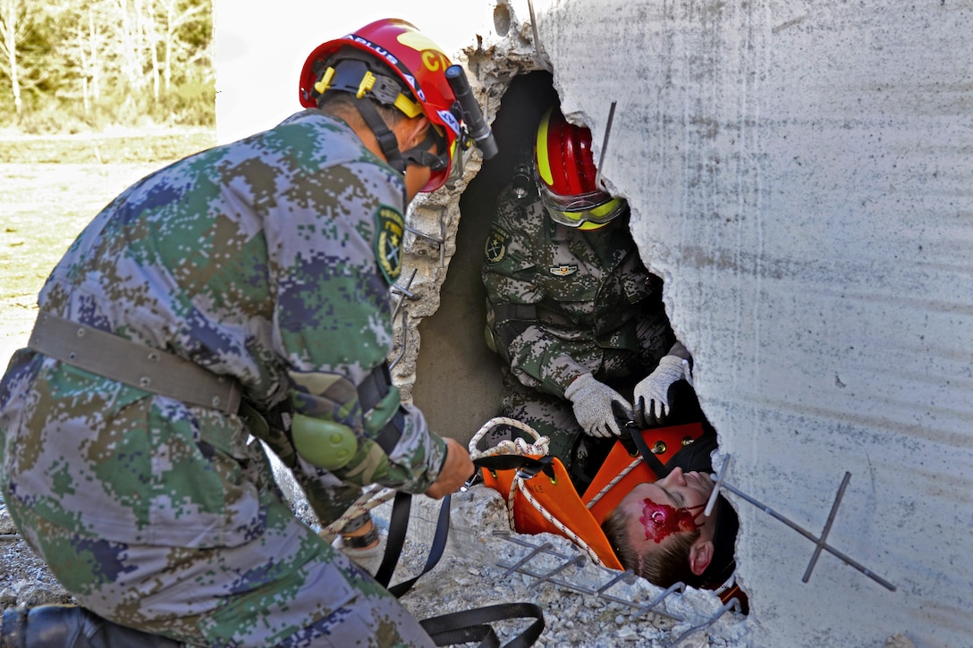 Chinese soldiers work to extract a simulated casualty during a disaster management exchange at Joint Base Lewis-McChord, Wash., Nov. 21, 2015. U.S. Army photos by Sgt. Jasmine Higgins