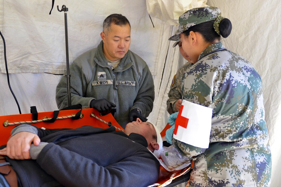 U.S. Chinese soldiers work together to provide medical assistance to a simulated casualty during a disaster management exchange at Joint Base Lewis-McChord, Wash., Nov. 21, 2015. U.S. Army photo by Sgt. Jasmine Higgins