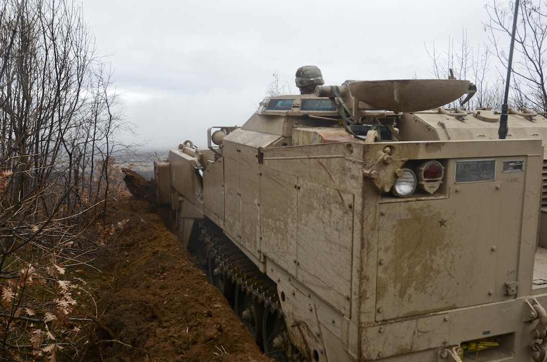 U.S. Army Spc. John McIntyre digs with an M9 armored combat earthmover to create a hull-down battle position for an M1A2 Abrams tank during Exercise Peace Sentinel at Novo Selo Training Center, Bulgaria, Nov. 23, 2015. McIntyre is a combat engineer assigned to the 3rd Infantry Division’s 5th Squadron, 7th Cavalry Regiment. Peace Sentinel is a joint training exercise that focuses on interoperability between Bulgarian and U.S. forces. U.S. Army photo by Staff Sgt. Steven M. Colvin