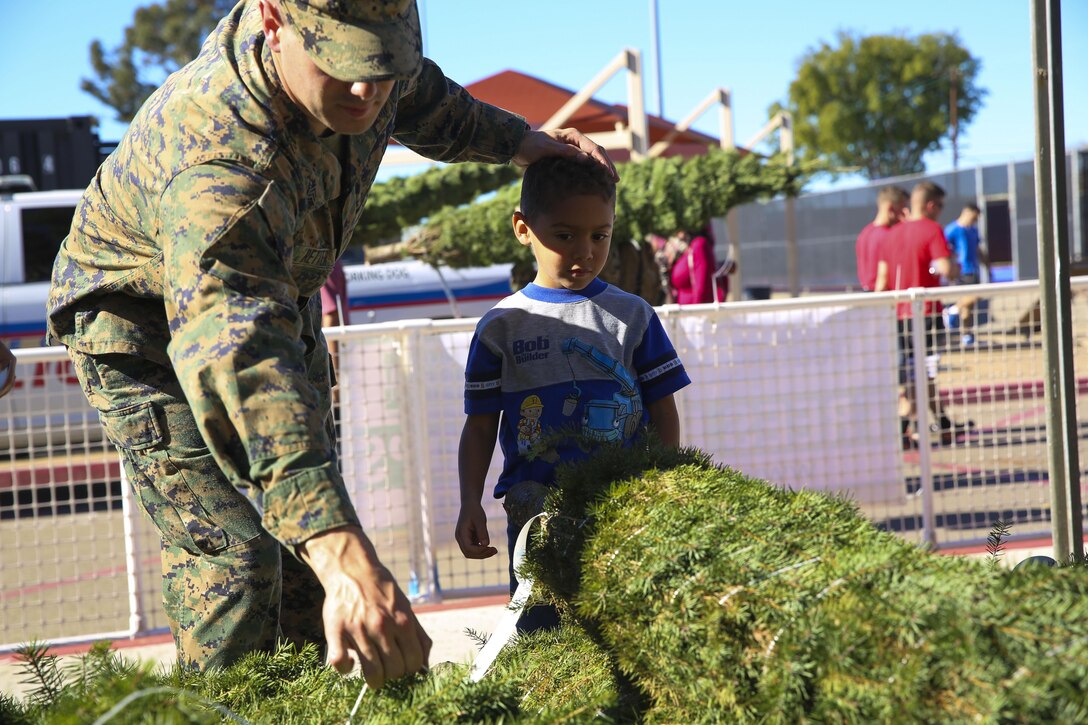 A Marine and his son pick out a Christmas tree during the Trees for Troops event aboard Marine Corps Air Station Miramar, Calif., Dec. 2. Trees for Troops is sponsored by the Christmas Spirit Foundation and FedEx and delivers more than 18,000 trees to more than 60 military bases worldwide every year. (U.S. Marine Corps photo by Cpl. Alissa P. Schuning/Released)