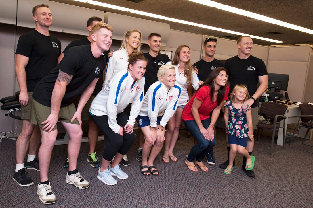 U.S. Women’s National Soccer Team athletes pose for a photo with wounded warriors and family members during a visit to Makalapa Clinic on Joint Base Pearl Harbor-Hickam, Hawaii, Dec. 3, 2015. The visit is one of several events honoring the nation’s military and veterans leading up to the 74th anniversary of Pearl Harbor Day. U.S. Navy photo by Petty Officer 2nd Class Jerome D. Johnson