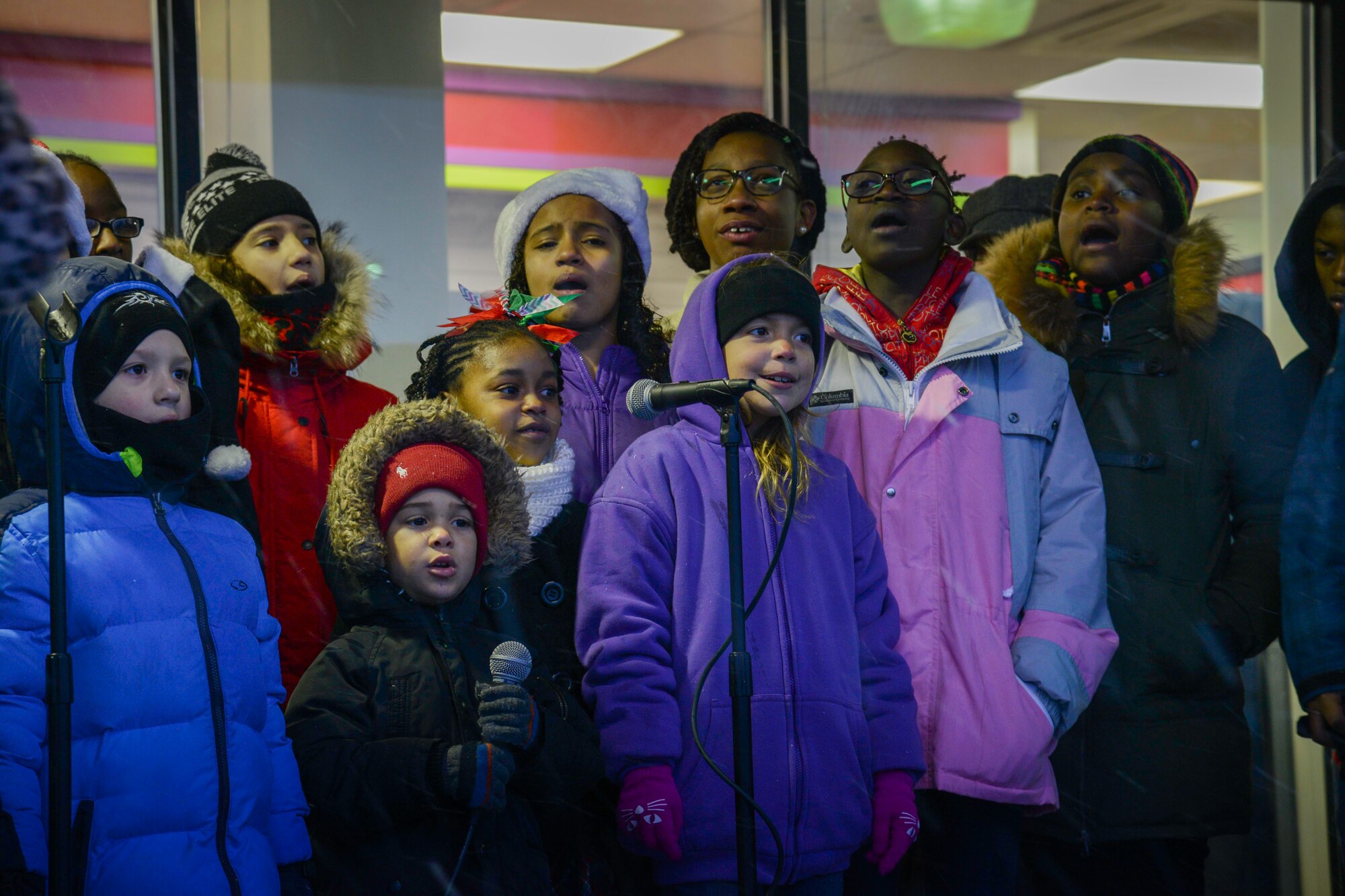 The base chapel gospel service children's choir sings carols during the annual Holiday Tree Lighting ceremony at Osan Air Base, Republic of Korea, Dec. 3, 2015. The choir sang “Silent Night” and “Deck The Halls” alongside the audience during the ceremony. (U.S. Air Force photo/Airman 1st Class Dillian Bamman)