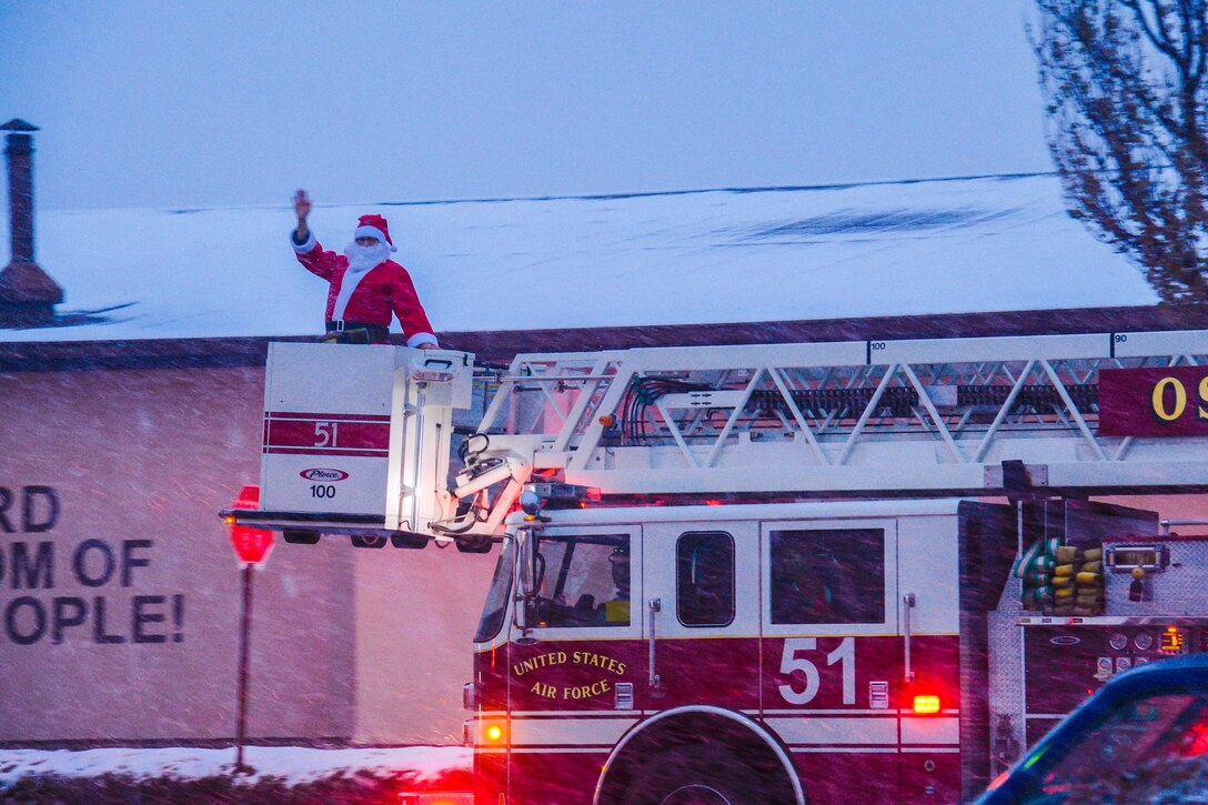 A 51st Civil Engineer Squadron fire truck ferries Santa Claus to the annual Holiday Tree Lighting ceremony at Osan Air Base, Republic of Korea, Dec. 3, 2015. Children of Team Osan visited with Santa and shared their holiday wishes following the ceremony. (U.S. Air Force photo/Airman 1st Class Dillian Bamman)