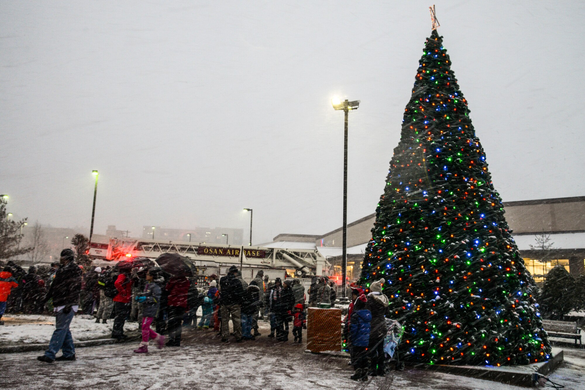 Team Osan members gather during the annual Holiday Tree Lighting ceremony at Osan Air Base, Republic of Korea, Dec. 3, 2015. Attendees enjoyed hot chocolate, sang carols and watched Santa Claus arrive during the ceremony. (U.S. Air Force photo/Airman 1st Class Dillian Bamman)