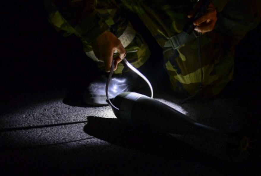 A 51st Civil Engineer Squadron explosive ordnance disposal technician measures the diameter of a simulated unexploded mortar round during a training scenario at Osan Air Base, Republic of Korea, Nov. 6, 2015. After finding unexploded ordnance, EOD stores them to perform controlled detonations in a secured area. (U.S. Air Force photo/Tech. Sgt. Travis Edwards)