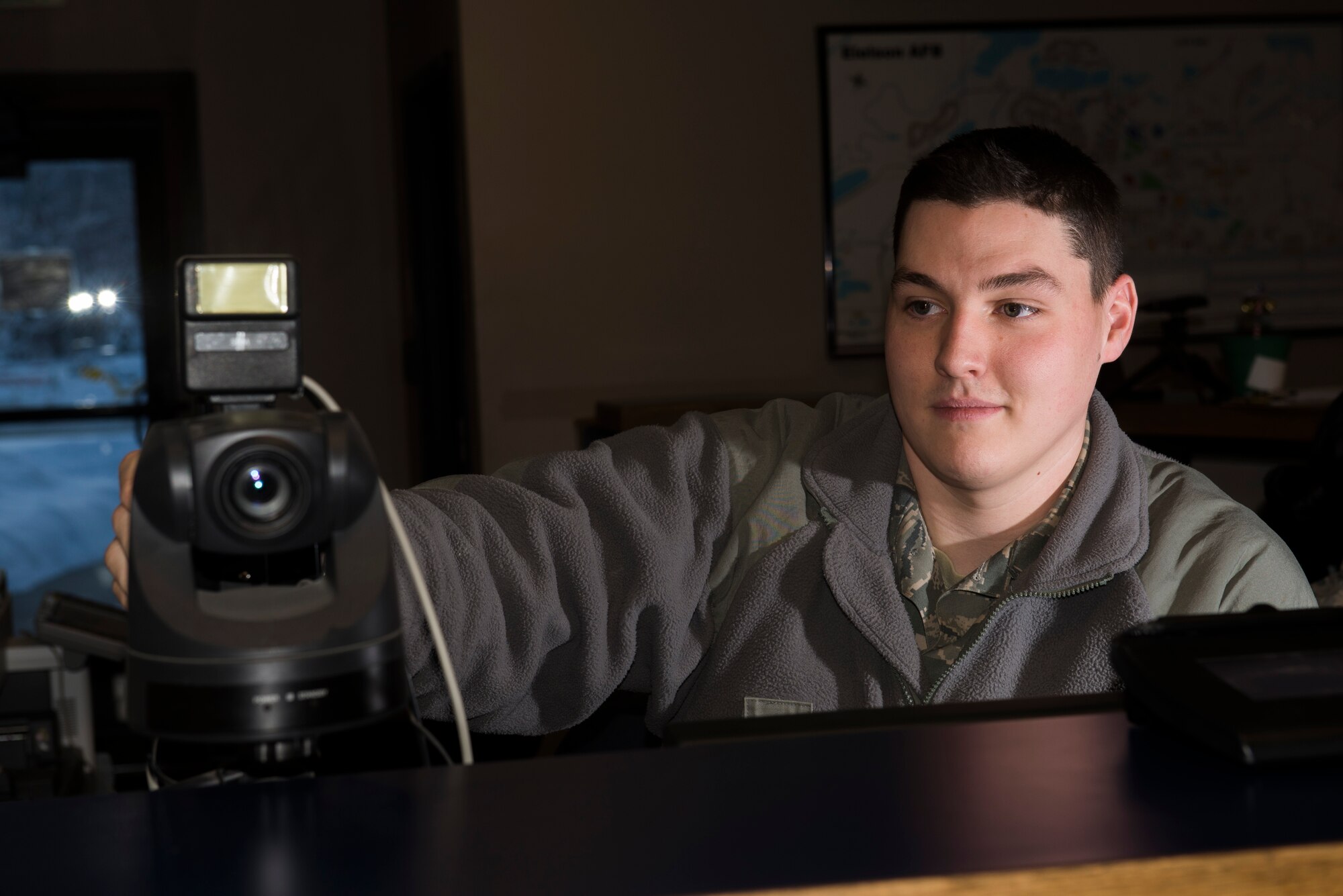 U.S. Air Force Airman 1st Class Seth Nolte, a 354th Security Forces Squadron Defender in the pass and registration section, adjusts a camera in the Visitor Control Center on Dec. 2, 2015, at Eielson Air Force Base, Alaska. Nolte has recently been involved with equipping and training personnel on Defense Biometric Identification System passes, which will help create an accurate record of visitors that enter the base after the duty day is over. (U.S. Air Force photo by Staff Sgt. Joshua Turner/Released)