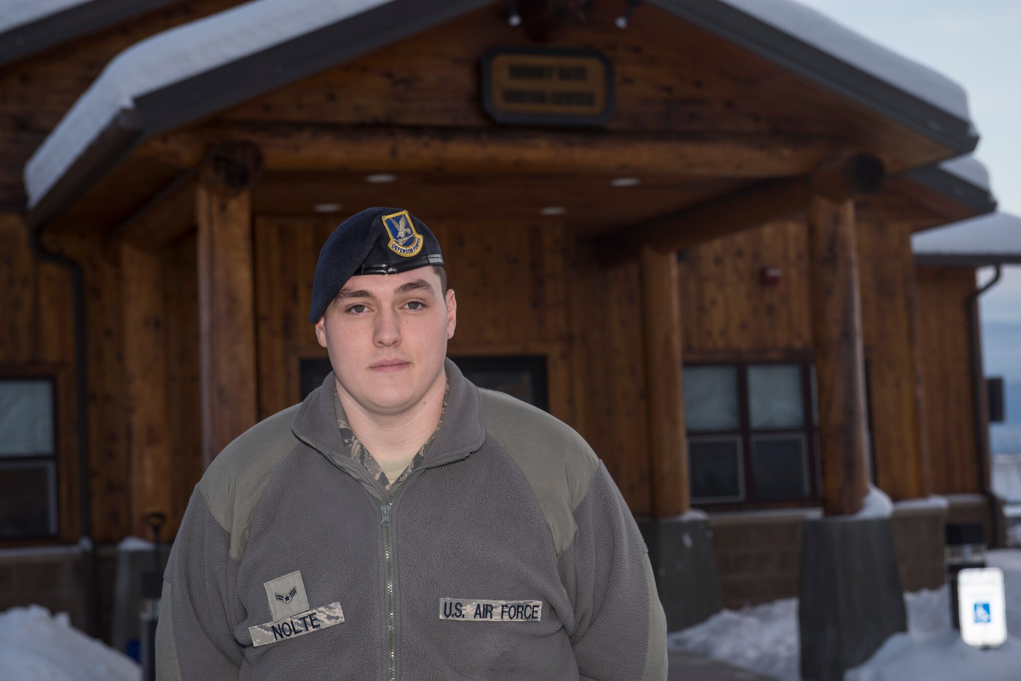 U.S. Air Force Airman 1st Class Seth Nolte, a 354th Security Forces Squadron Defender in the pass and registration section, stands in front of the Visitor Control Center on Dec. 2, 2015, at Eielson Air Force Base, Alaska. Nolte said he enjoys helping and interacting with the community along with providing assistance to the public. (U.S. Air Force photo by Staff Sgt. Joshua Turner/Released))