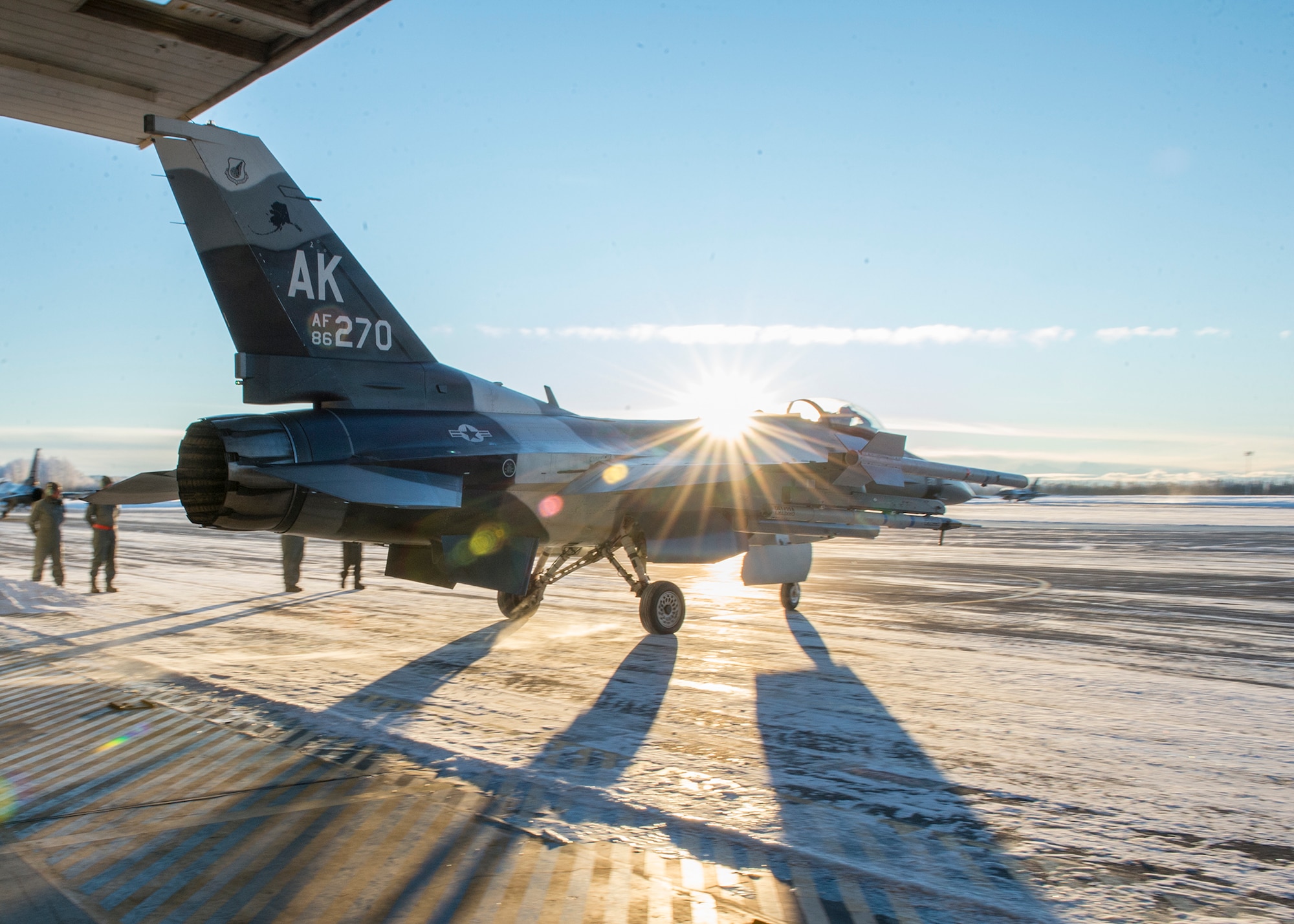 A U.S. Air Force F-16 Fighting Falcon fighter aircraft, assigned to the 18th Aggressor Squadron at Eielson Air Force Base, Alaska, leaves a hangar into minus 9-degree temperatures Dec. 1, 2015, for a sortie in the Joint Pacific Alaska Training Range Complex (JPARC). The Aggressors fly rain or shine, barring extreme inclement weather, to provide unparalleled training to U.S. and partner nations in the JPARC, the world’s largest instrumented air, ground and electronic combat training range. (U.S. Air Force photo by Staff Sgt. Shawn Nickel/Released)