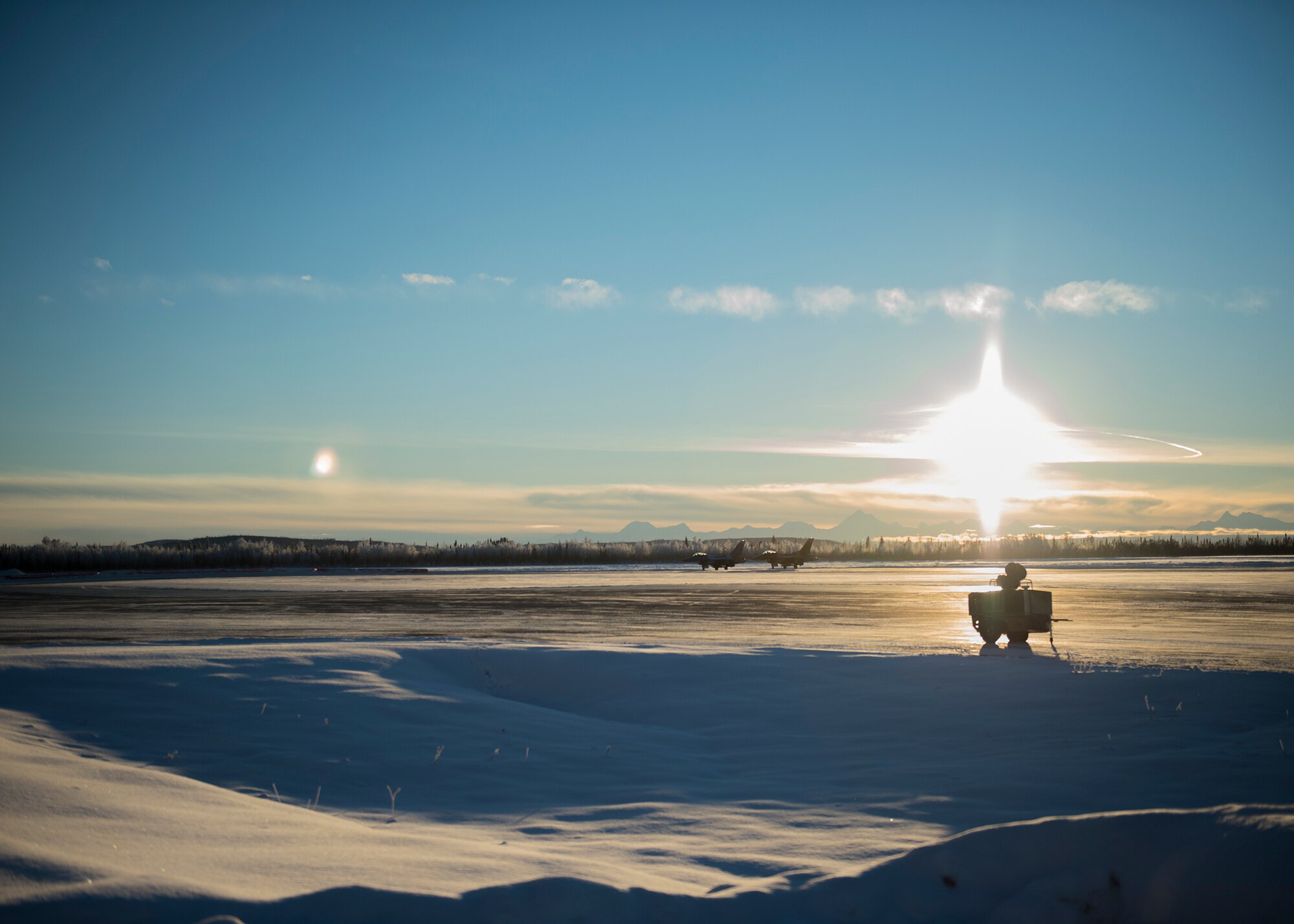 Two U.S. Air Force F-16 Fighting Falcon fighter aircraft, assigned to the 18th Aggressor Squadron at Eielson Air Force Base, Alaska, taxi between snow drifts on the flightline Dec. 1, 2015, on their way to a training sortie in the Joint Pacific Alaska Training Range Complex (JPARC). The Aggressors fly rain or shine, barring extreme inclement weather, to provide unparalleled training to U.S. and partner nations in the JPARC, the world’s largest instrumented air, ground and electronic combat training range. (U.S. Air Force photo by Staff Sgt. Shawn Nickel/Released)