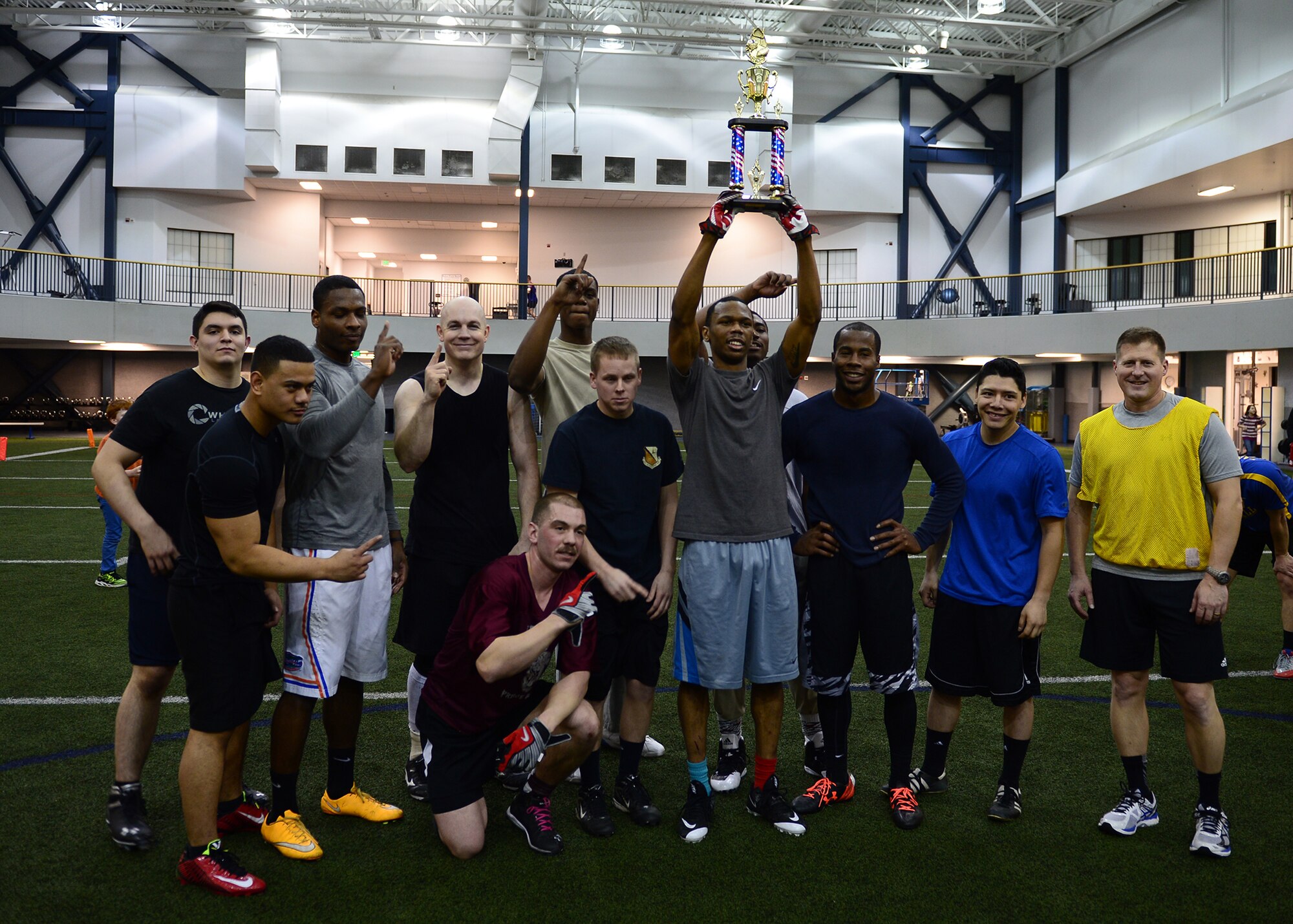Col. Michael Winkler (right), the 354th Fighter Wing commander, celebrates with members of the 354th Civil Engineer Squadron, who won the 2015 Intramural Football Championship in the Baker Field House at Eielson Air Force Base, Alaska, Dec. 3, 2015. The season ended with a 24-19 win against the 354th Security Forces Squadron. (U.S. Air Force photo by Staff Sgt. Shawn Nickel/Released)
