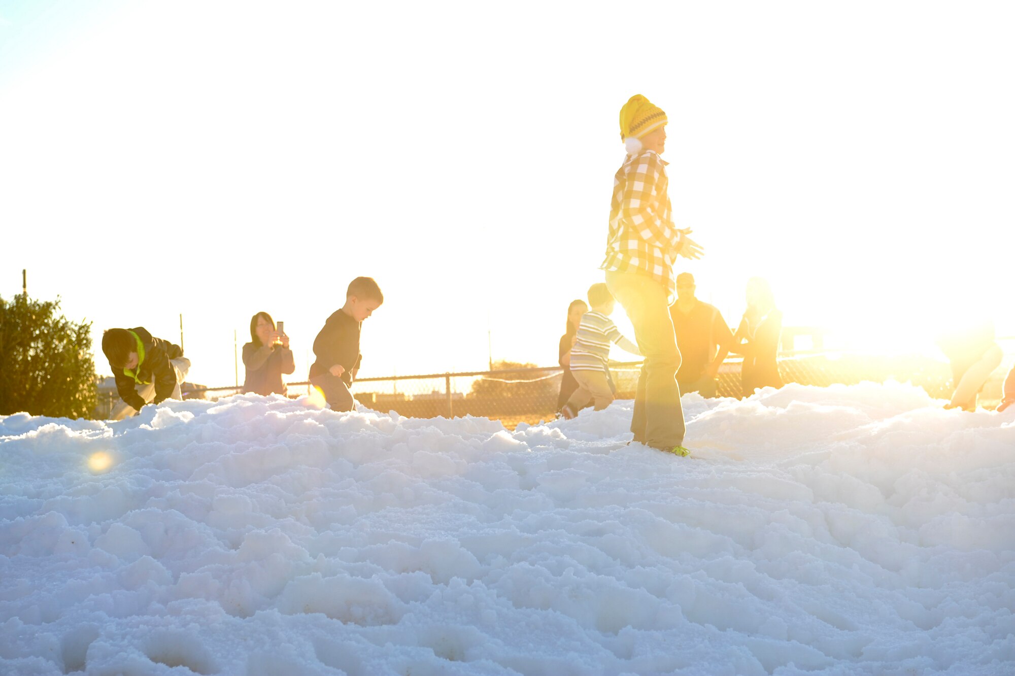 Children play in the snow during the Starry, Snowy, Southwest Night event at Davis-Monthan Air Force Base, Ariz., Dec. 3, 2015. Sixty tons of snow were made for the event and divided into two areas for different age groups. (U.S. Air Force photo by Airman Basic Nathan H. Barbour/Released)