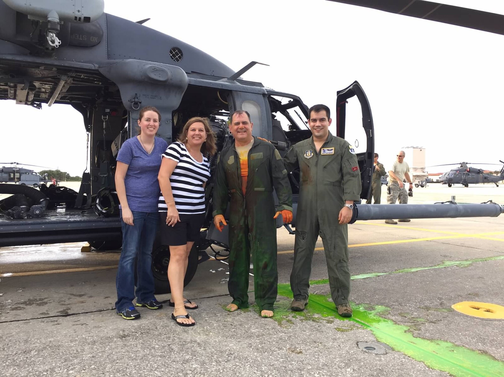 PATRICK AIR FORCE BASE, Fla. - Chief Master Sgt. Lazaro Ibarra, 301st Rescue Squadron special mission aviator here, stands bare foot with his family following his fini-flight ceremony, Dec. 2.  Fellow 301st RQS air crew doused Ibarra with sea dye before making a green imprint of the chief’s bare feet on a ceiling tile, which will be placed in squadron’s hallowed halls alongside so many other honorees.  From left is Ibarra’s daughter Michelle, his wife Barbara and far right, son Staff Sgt. Daniel Ibarra, 39th Rescue Squadron loadmaster here. (Courtesy photo)