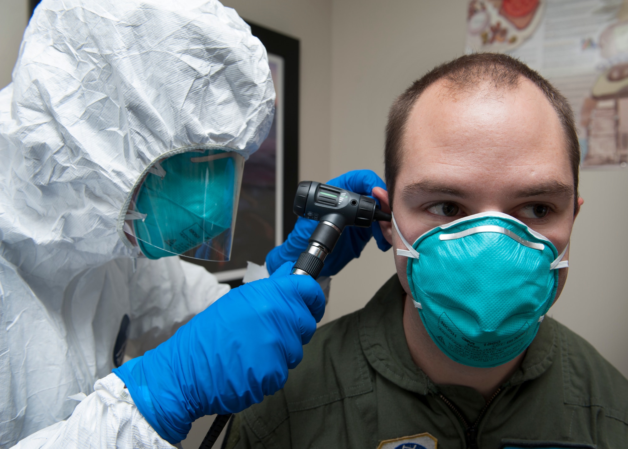Maj. Troy Pearce, 436th Medical Operations Squadron staff physician, uses an otoscope to examine the ears of Senior Airman Peter Cannizzaro, 9th Airlift Squadron loadmaster, during an Ebola Response Plan and Transport exercise Nov. 3, 2015, at the 436th Medical Group Clinic on Dover Air Force Base, Del. Cannizzaro volunteered to play the role of a suspected Ebola virus carrying patient. (U.S. Air Force photo/Senior Airman Zachary Cacicia)