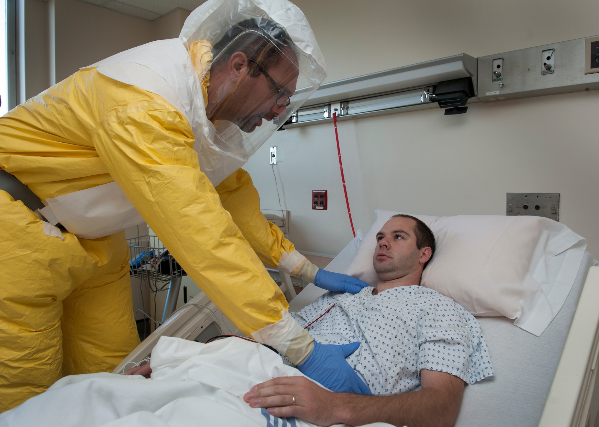 Dr. Mike Benninghoff, Christiana Care intensivist, examines the abdomen of Senior Airman Peter Cannizzaro, 9th Airlift Squadron loadmaster, during an Ebola Response Plan and Transport exercise Nov. 3, 2015, at the Wilmington Hospital in Wilmington, Del. Wilmington Hospital is currently the only hospital in Delaware that is equipped to handle a possible Ebola patient. (U.S. Air Force photo/Senior Airman Zachary Cacicia)