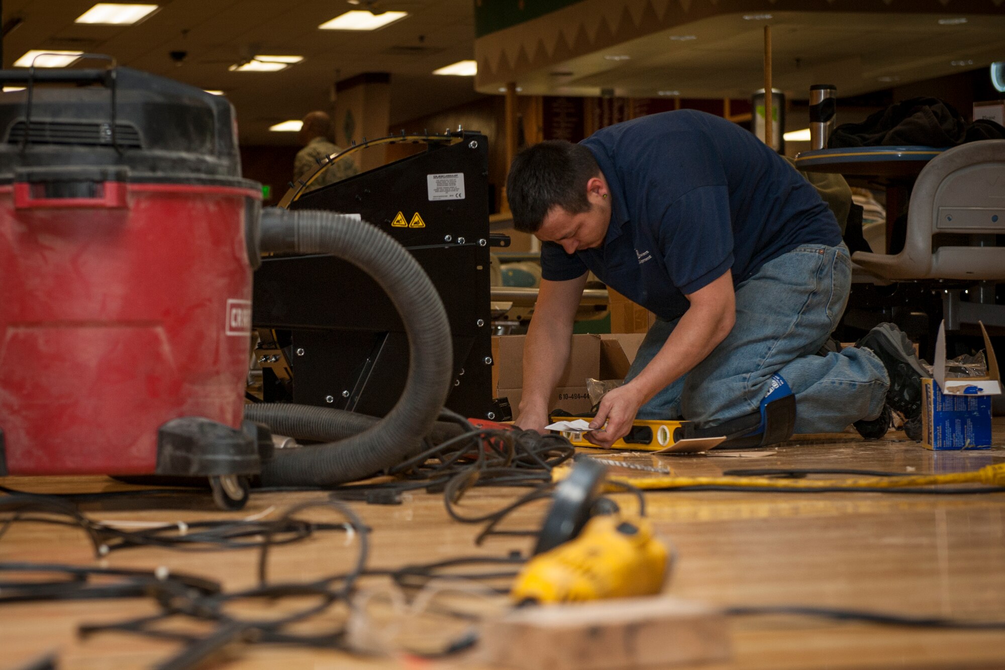 PETERSON AIR FORCE BASE, Colo. – Cliff Osada, Bowler’s Equipment contractor, uses a level as he installs a new ball return at the Peterson Bowling Center, Dec. 3, 2015. The bowling center made upgrades to the interior, including the ball returns, new carpet throughout the facility and new furniture. The best part of the makeover was the old hard-top tables being replaced with couches and coffee tables. (U.S. Air Force photo by Senior Airman Rose Gudex)
