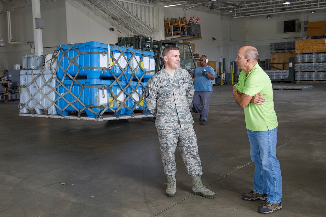 Chief Master Sgt. Jason Lamoureux, 45th Space Wing command chief, discusses air terminal operations with Rudi Zayas, Air Terminal manager, while Matthew Harp, Vehicle Operations augmenter, directs one of four 2,500-pound ration pallets being loaded in support of the weekly airlift to Ascension Island at Patrick Air Force Base, Fla., Nov. 30, 2015. The chief met with 45th LRS personnel and was introduced to facilities the 45th LRS uses in day-to-day operations. (U.S. Air Force photo by Matthew Jurgens/Released)